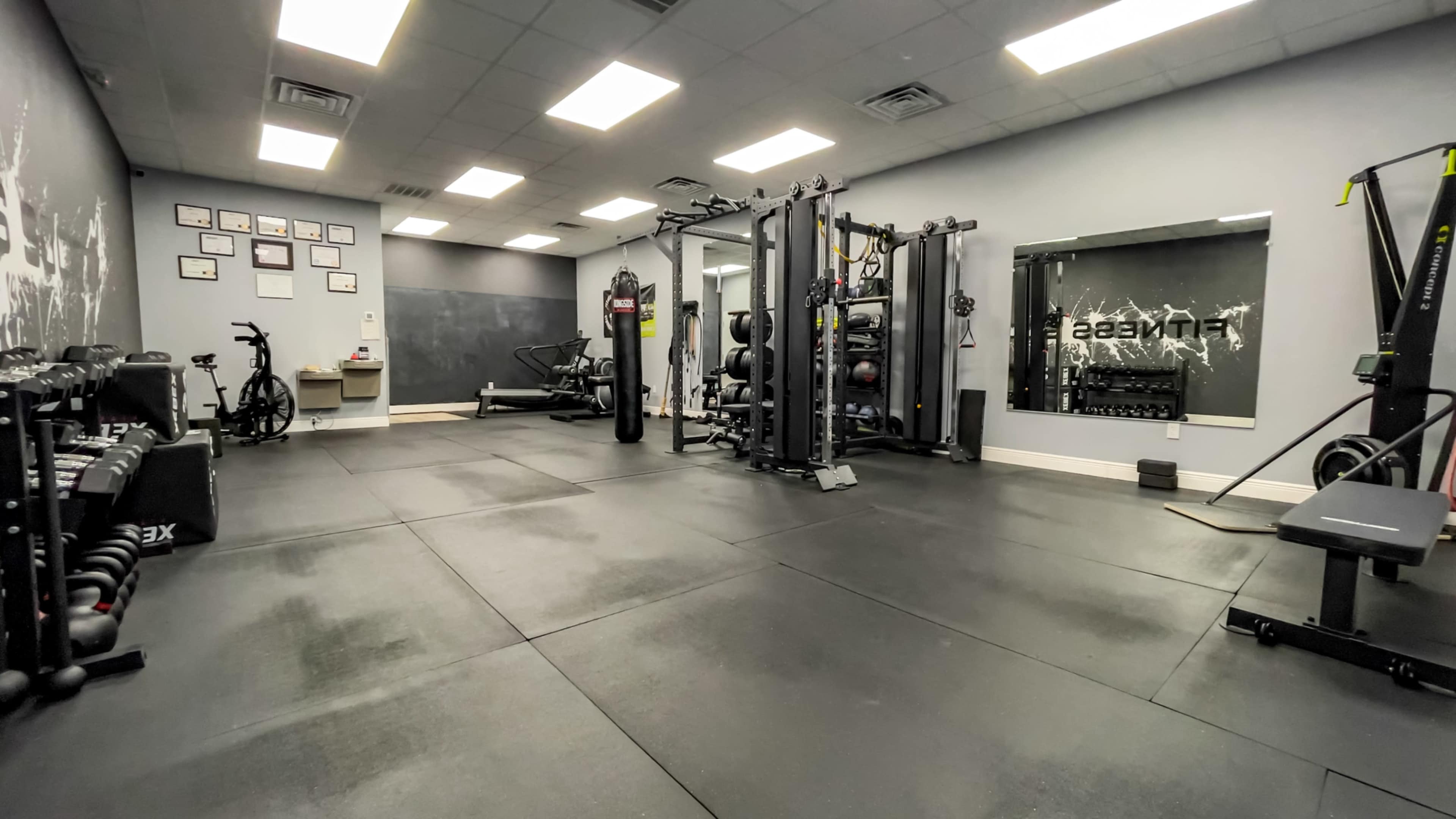 A spacious gym area equipped with various fitness machines, weights, and exercise mats.