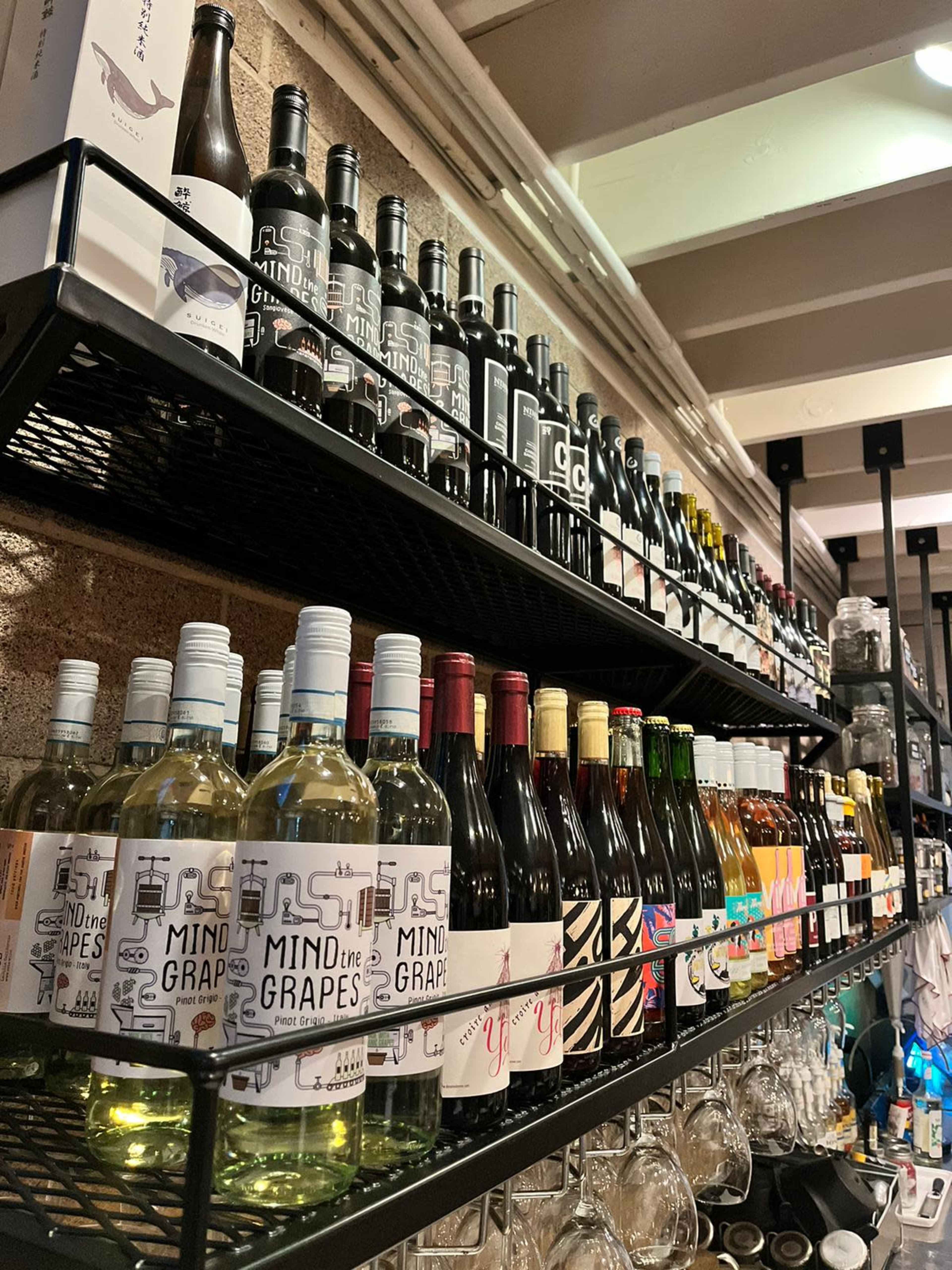 A shelf filled with various bottles of wine and spirits arranged in neat rows.