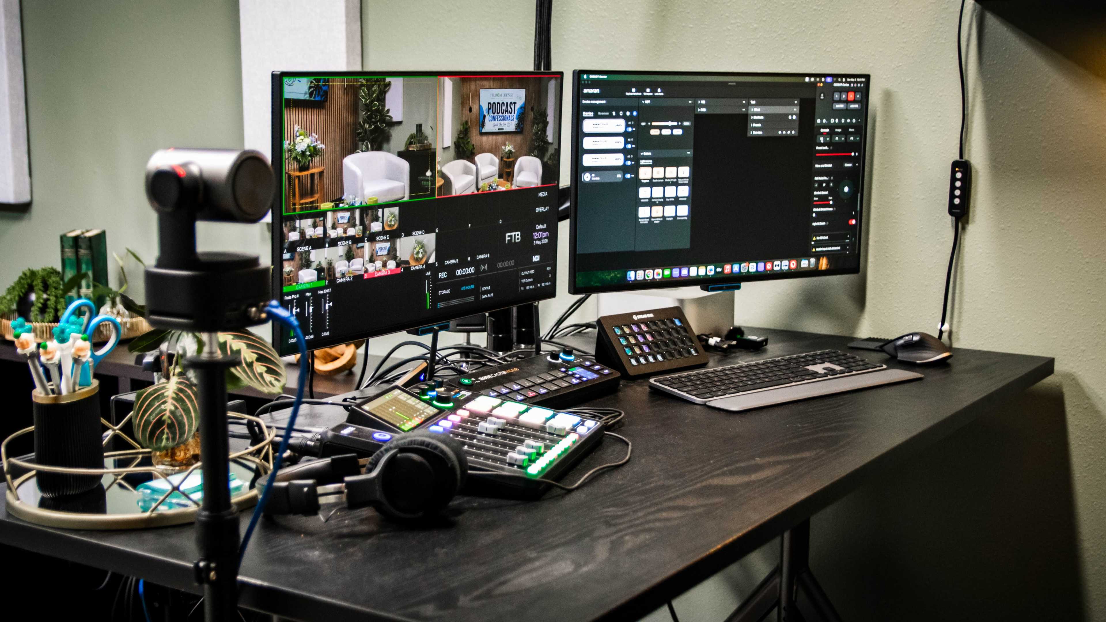 The image shows a dual-monitor setup on a desk, featuring a video production interface on one screen and various control panels on the other, with equipment like a microphone and headphones nearby.