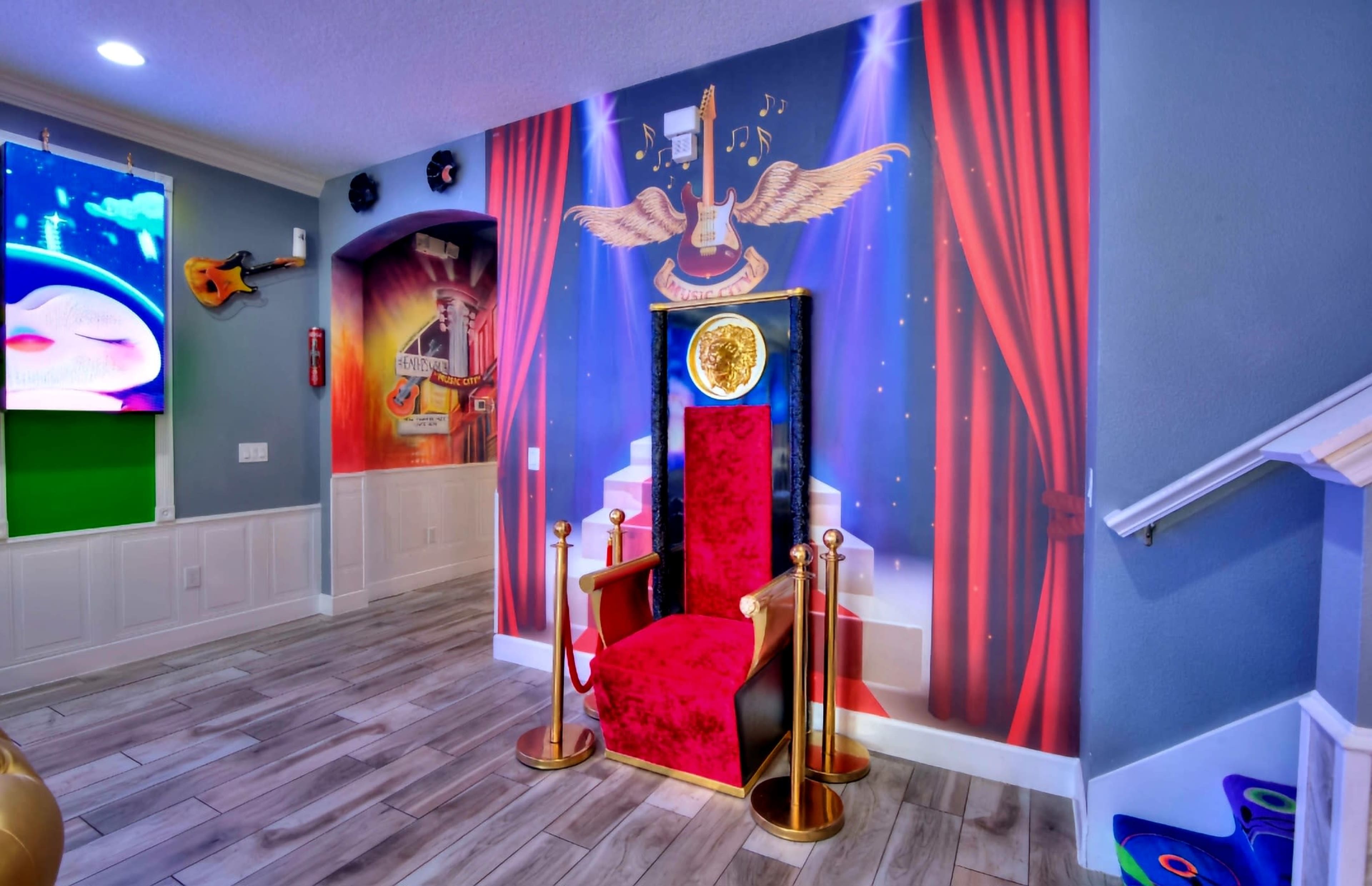 A velvet throne with gold accents set against a vibrant mural featuring musical elements and red curtains.