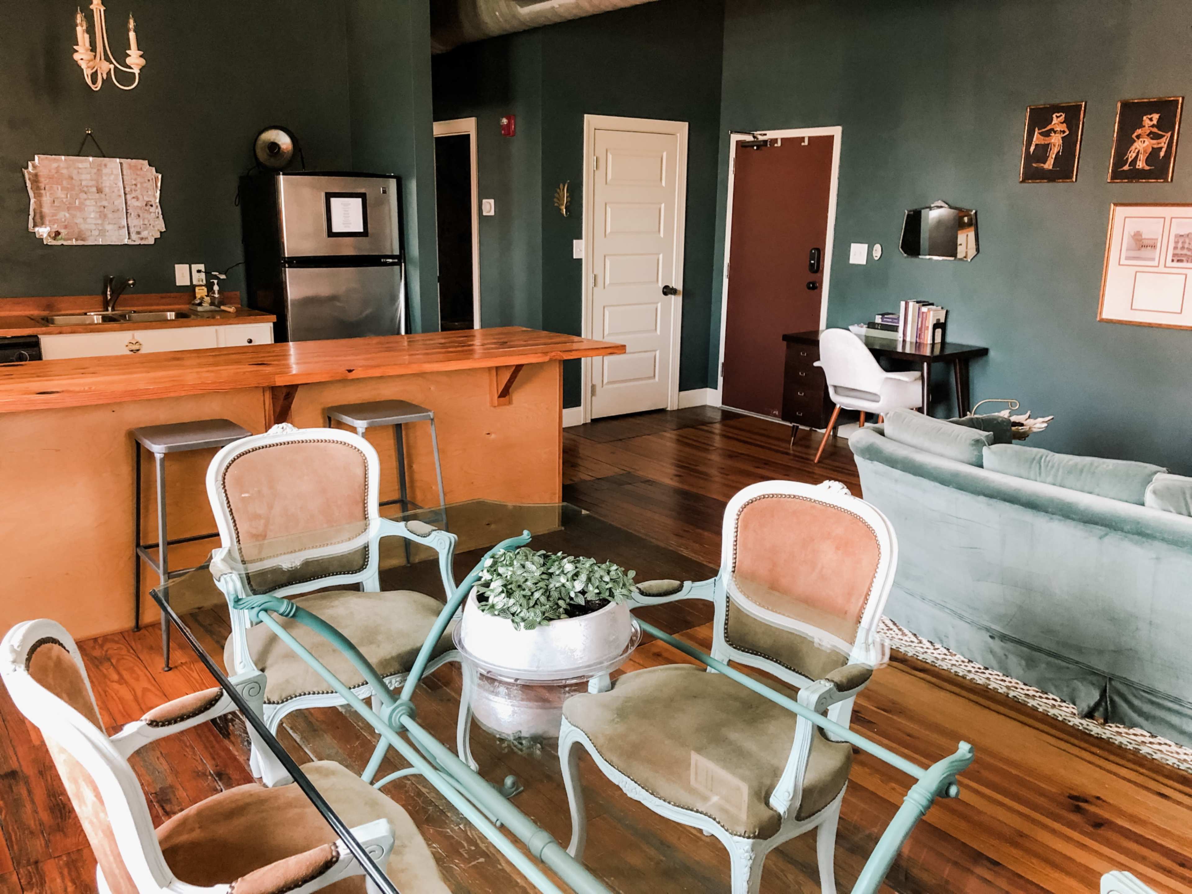 A furnished living space with a kitchen area, dining table, and comfortable seating.