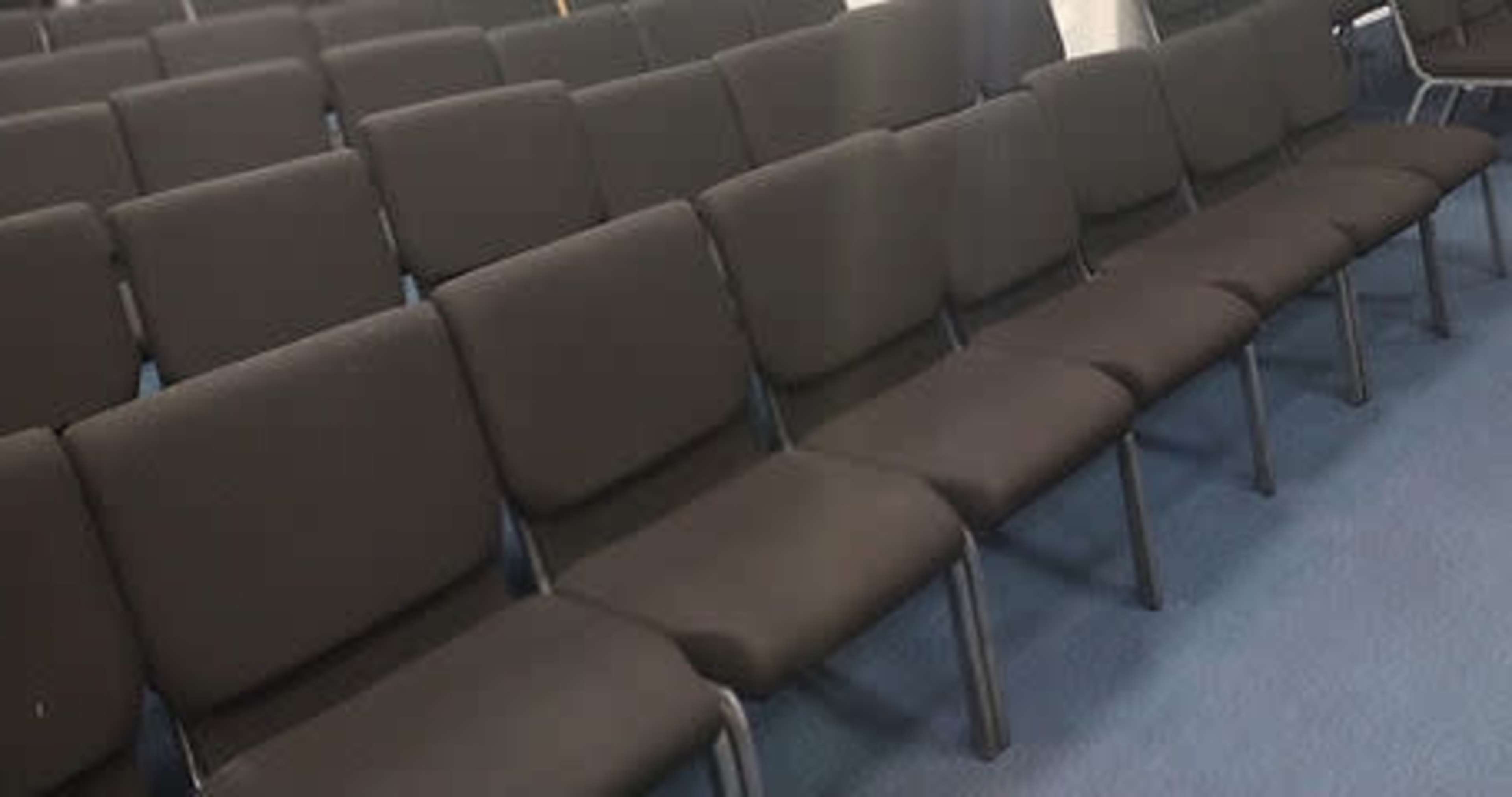 A row of black chairs arranged in a seating area.