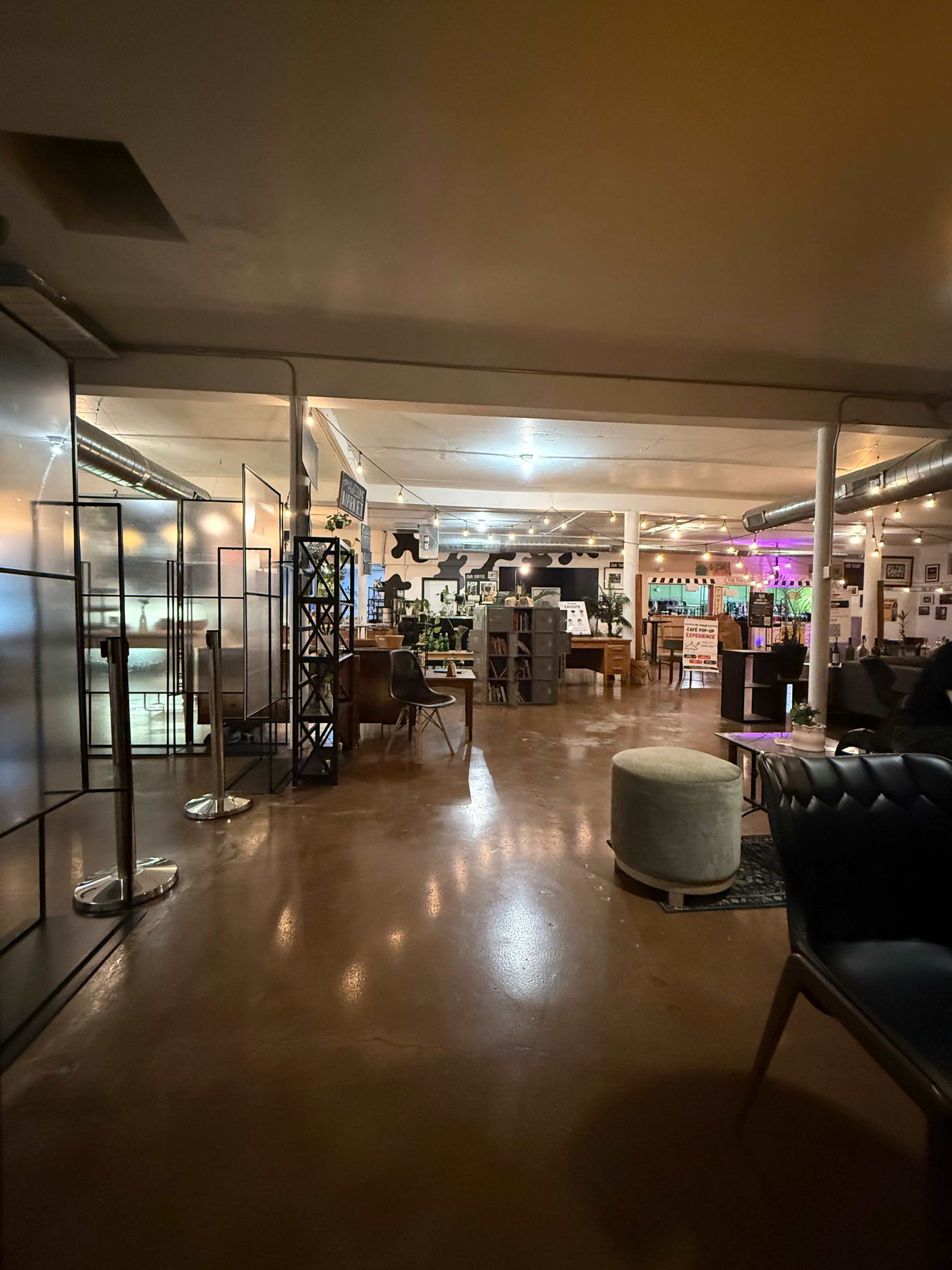 The image shows a spacious indoor area with various seating arrangements and decorative elements, illuminated by soft lighting.