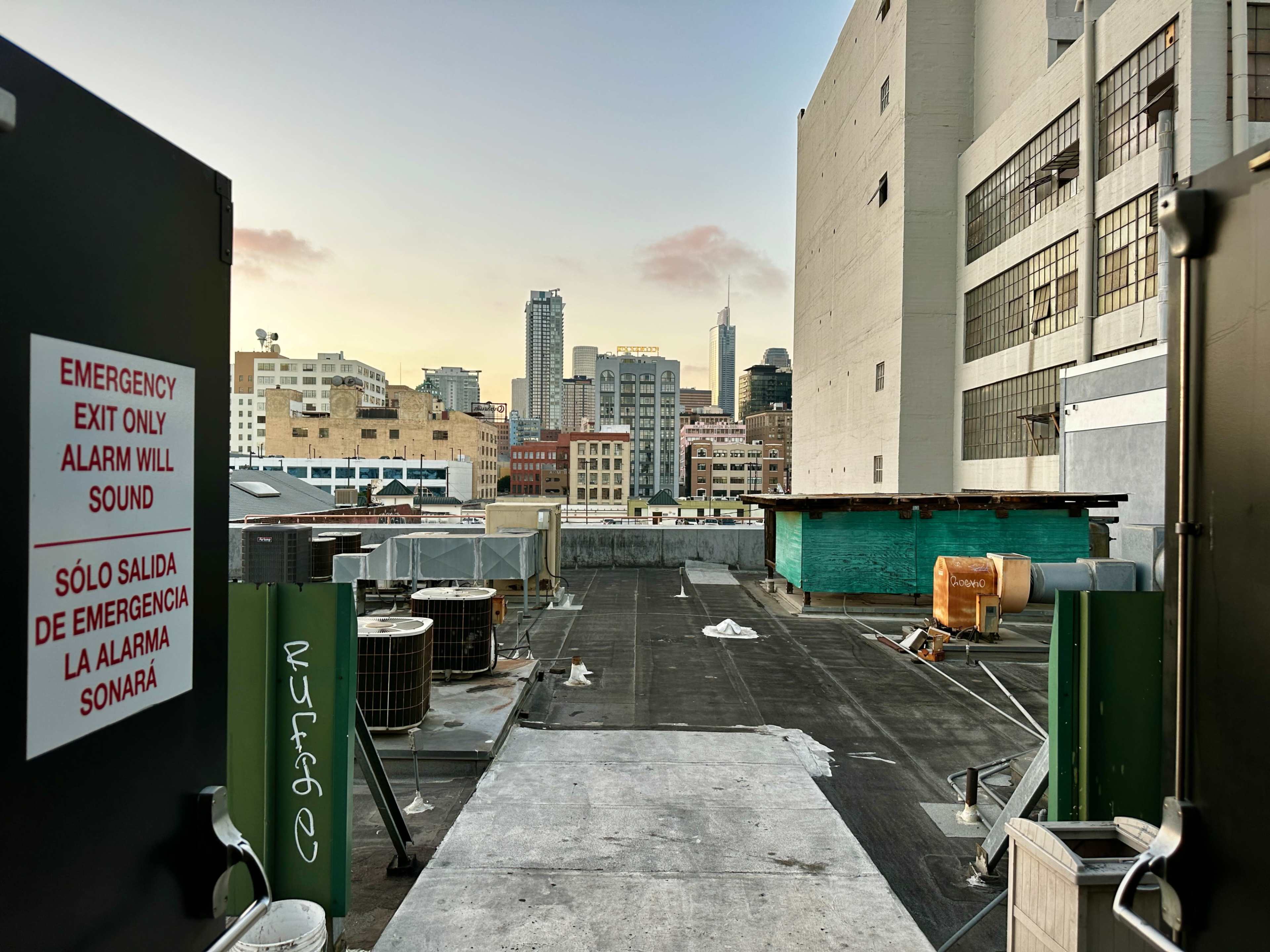 A rooftop space with equipment and a view of skyscrapers in the background, including the iconic Empire State Building.