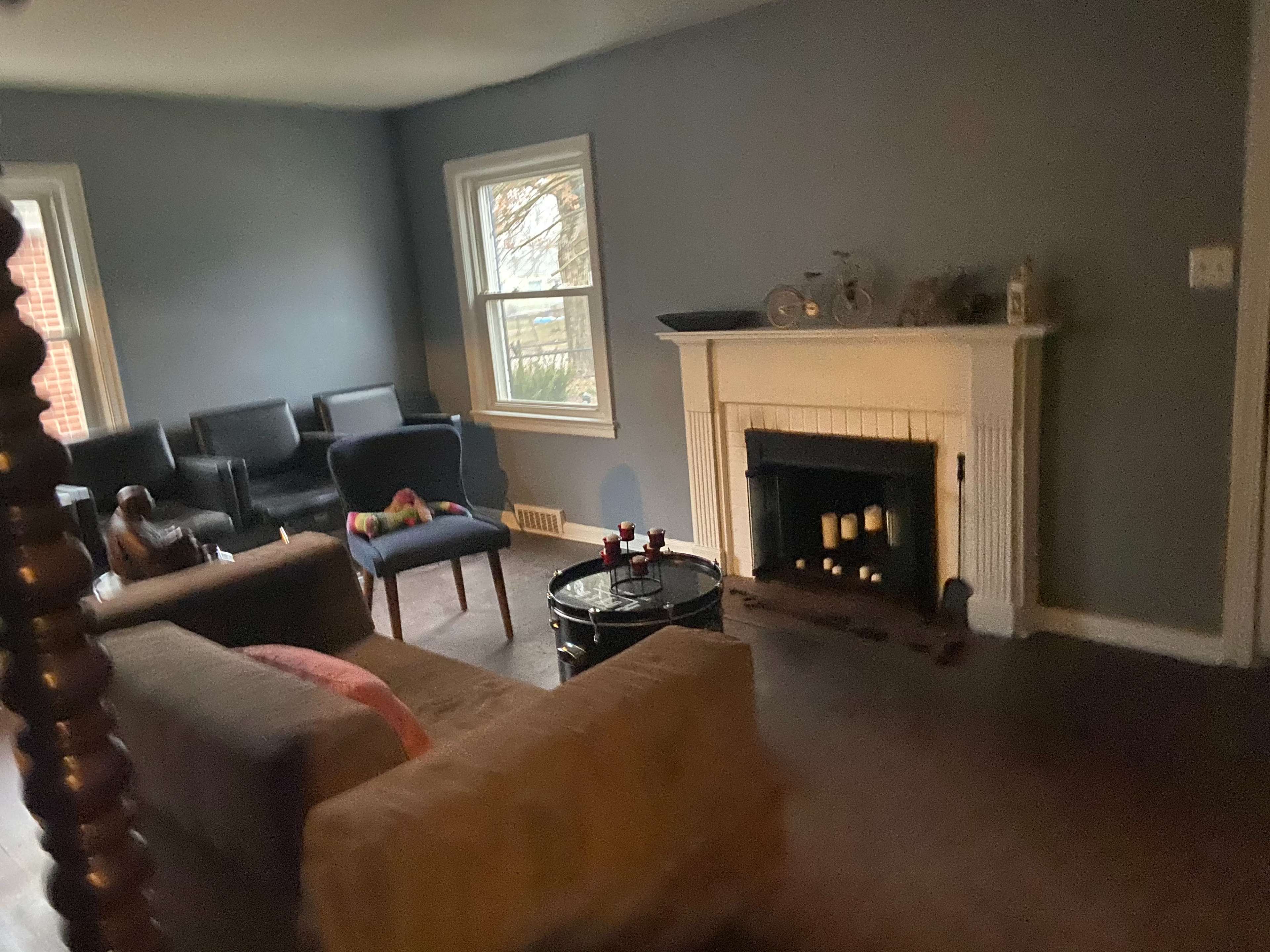 A living room with a fireplace, two armchairs, a sofa, and a coffee table.