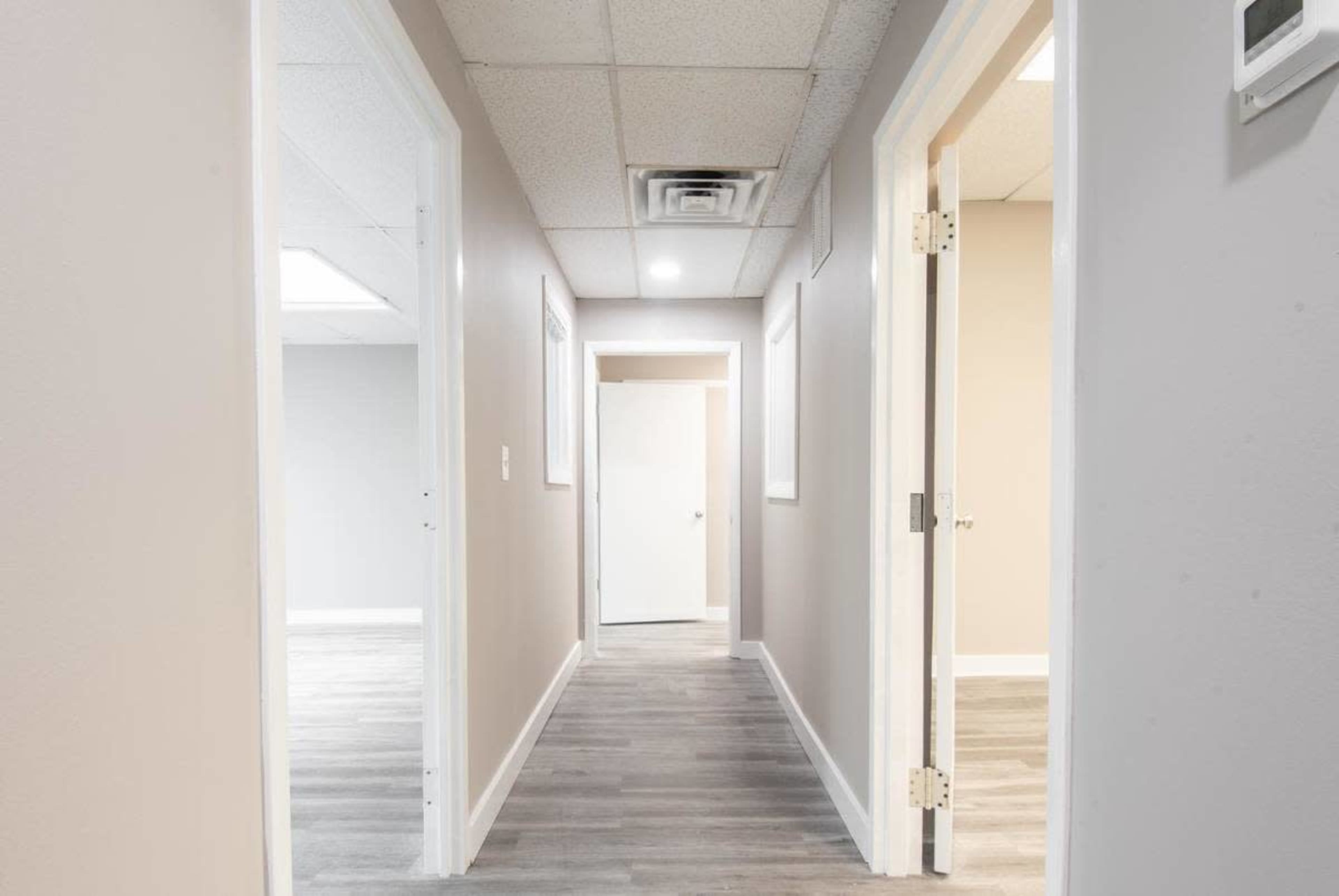 A hallway in a building with multiple doors leading to various rooms.