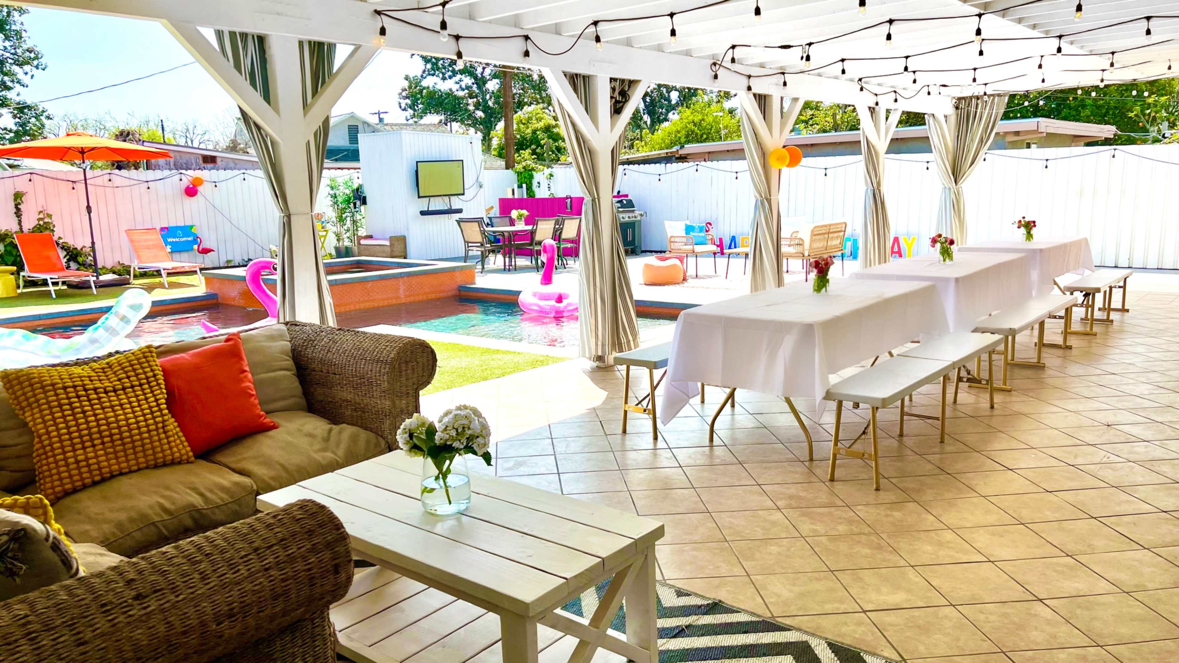 The image shows a spacious outdoor patio area with a pool, lounge seating, and festive decorations.