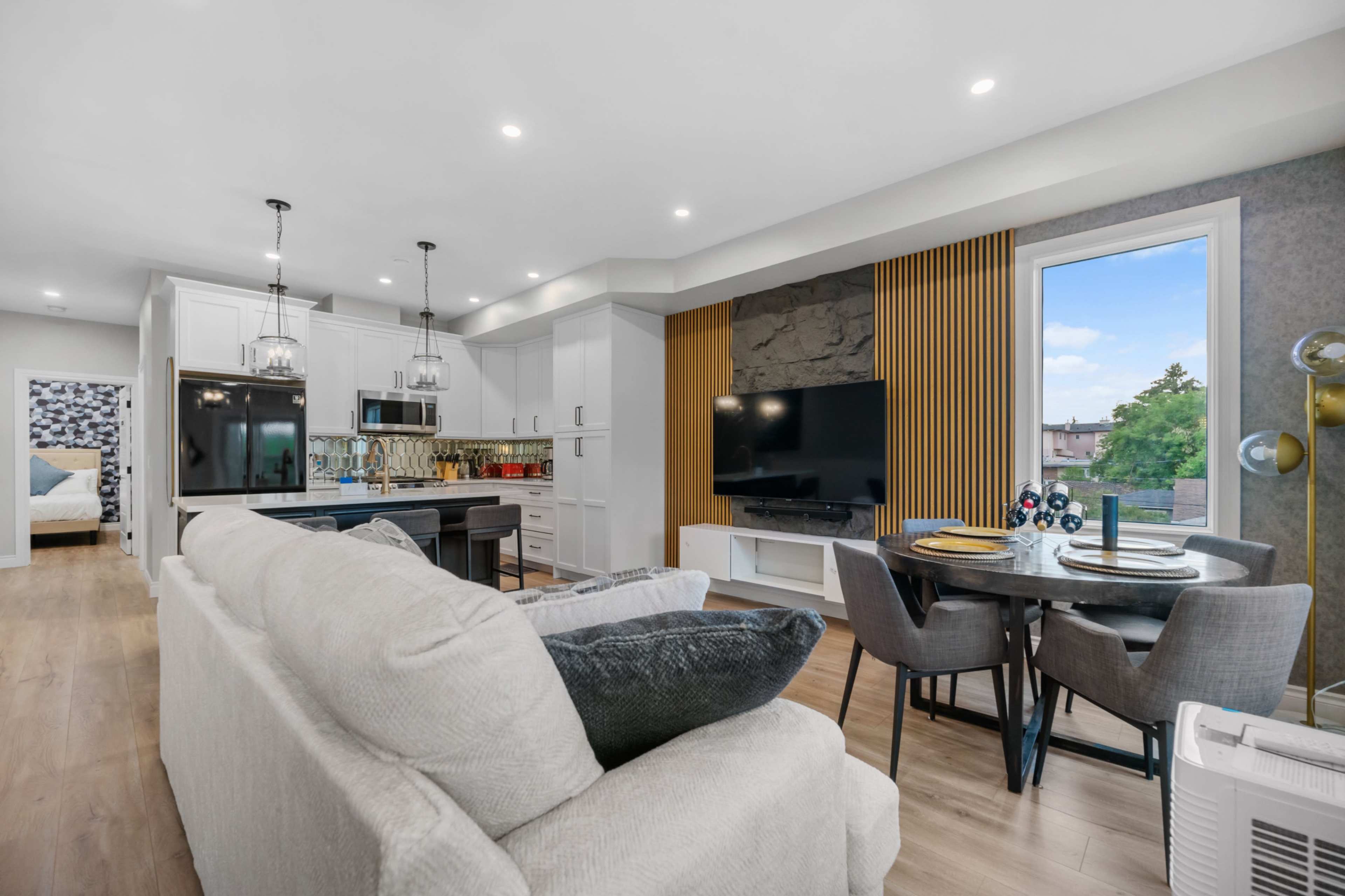 A modern open-concept living and dining area with a kitchen, a dining table, and a comfortable seating arrangement.