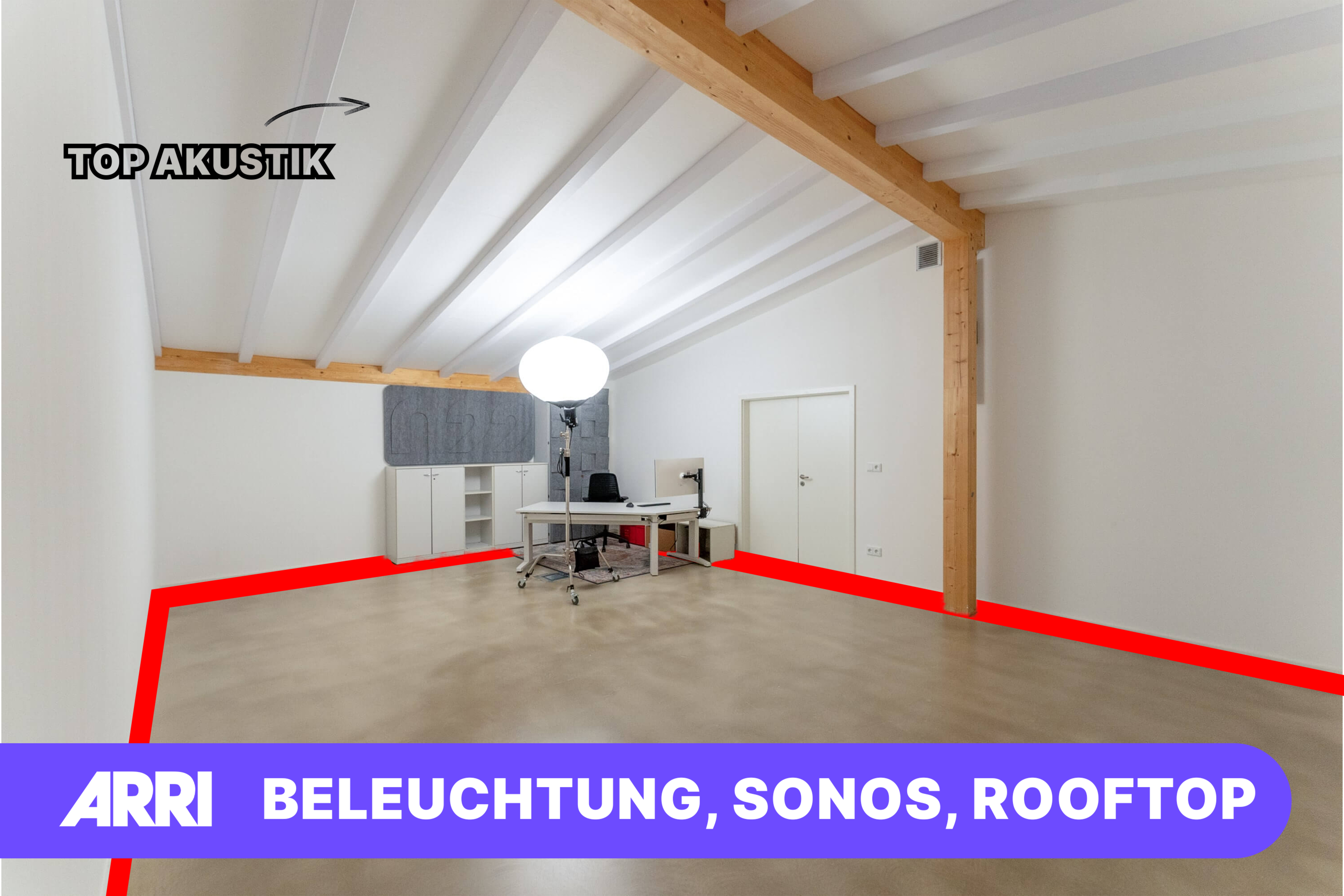 A spacious, well-lit room with a wooden beam ceiling, featuring a minimalist desk and a large circular light source.