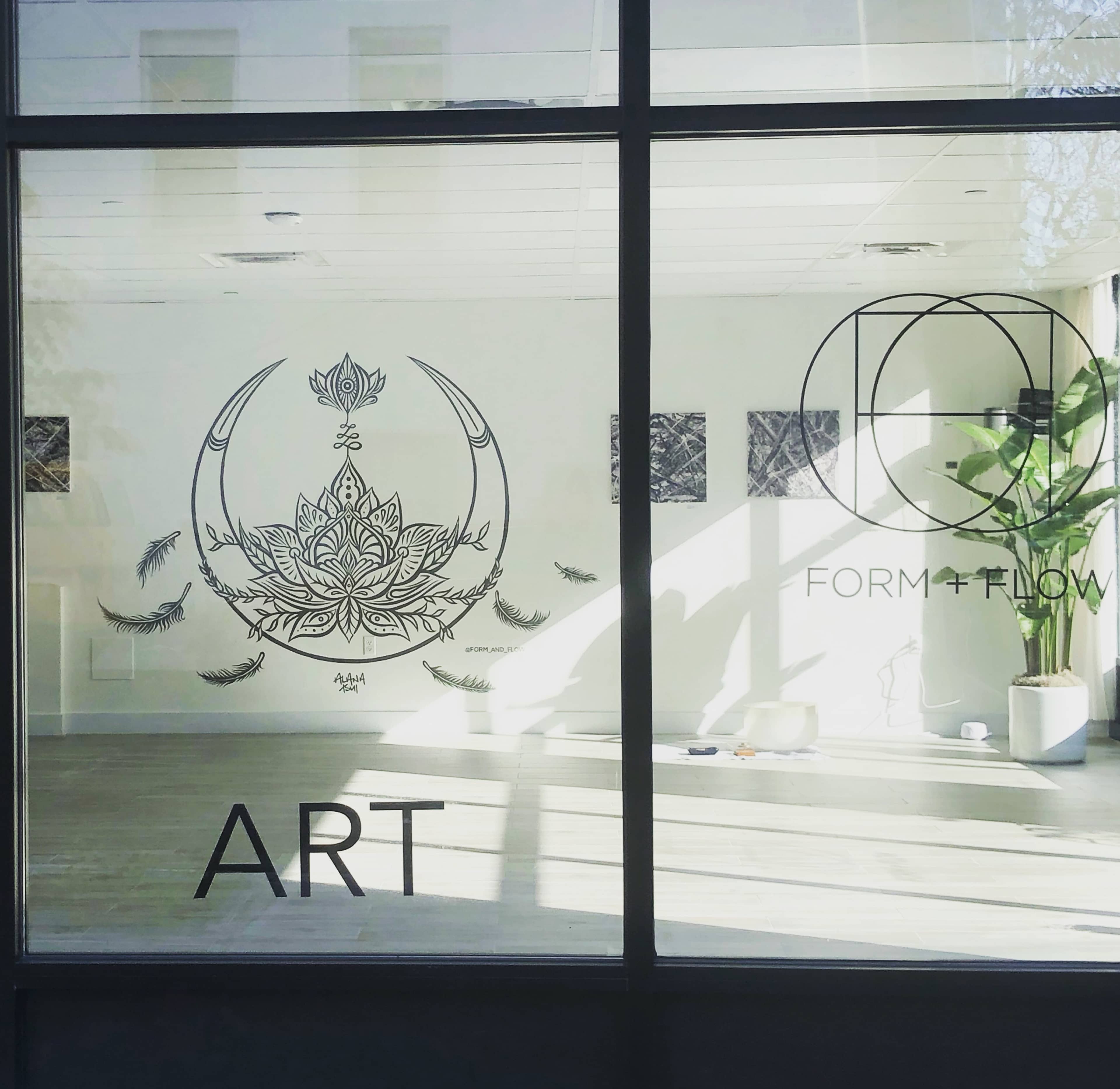 A window showcasing a minimalist interior with a large lotus design and "FORM + FLOW" branding.