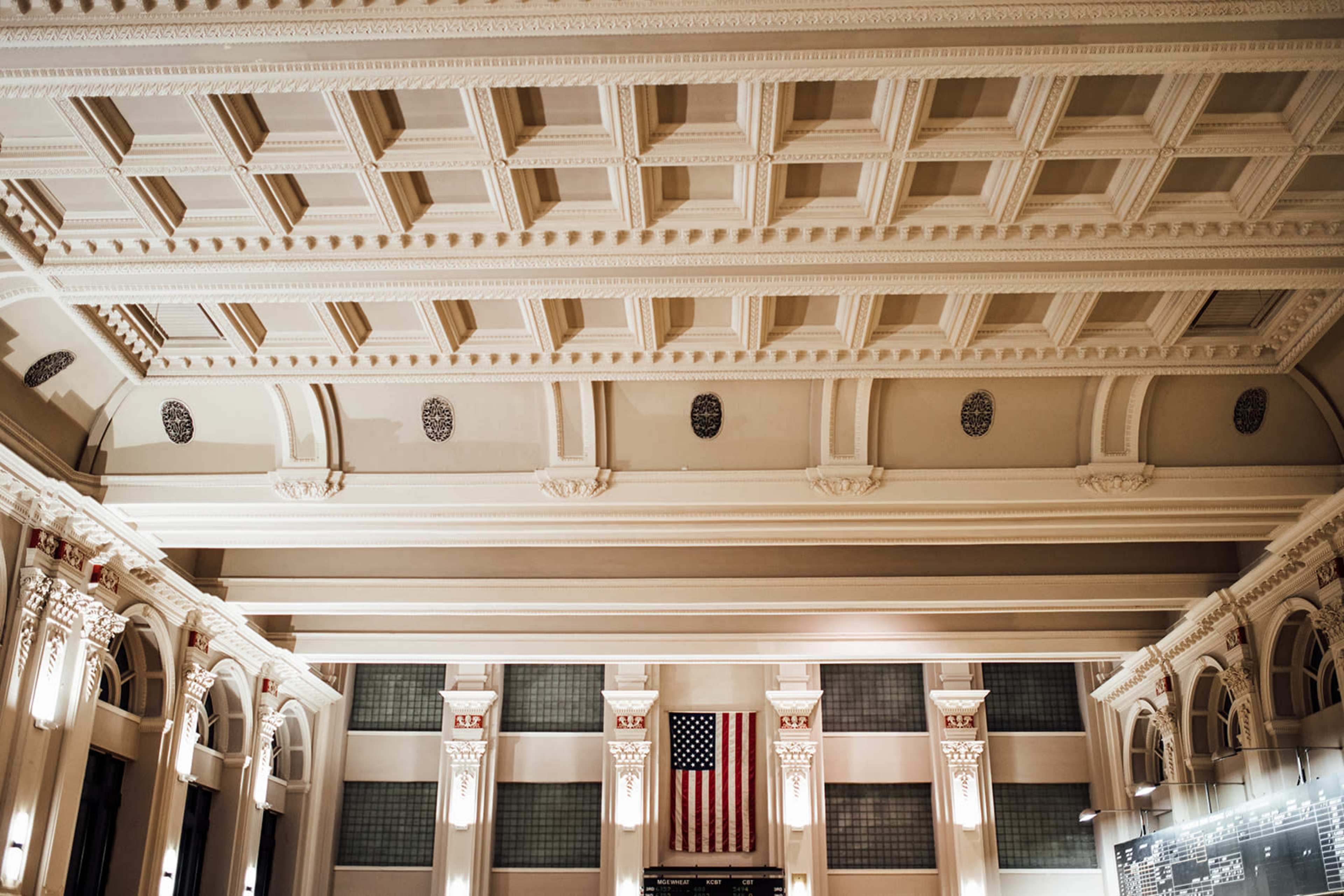 A spacious interior with a high ornamental ceiling and an American flag displayed on the wall.