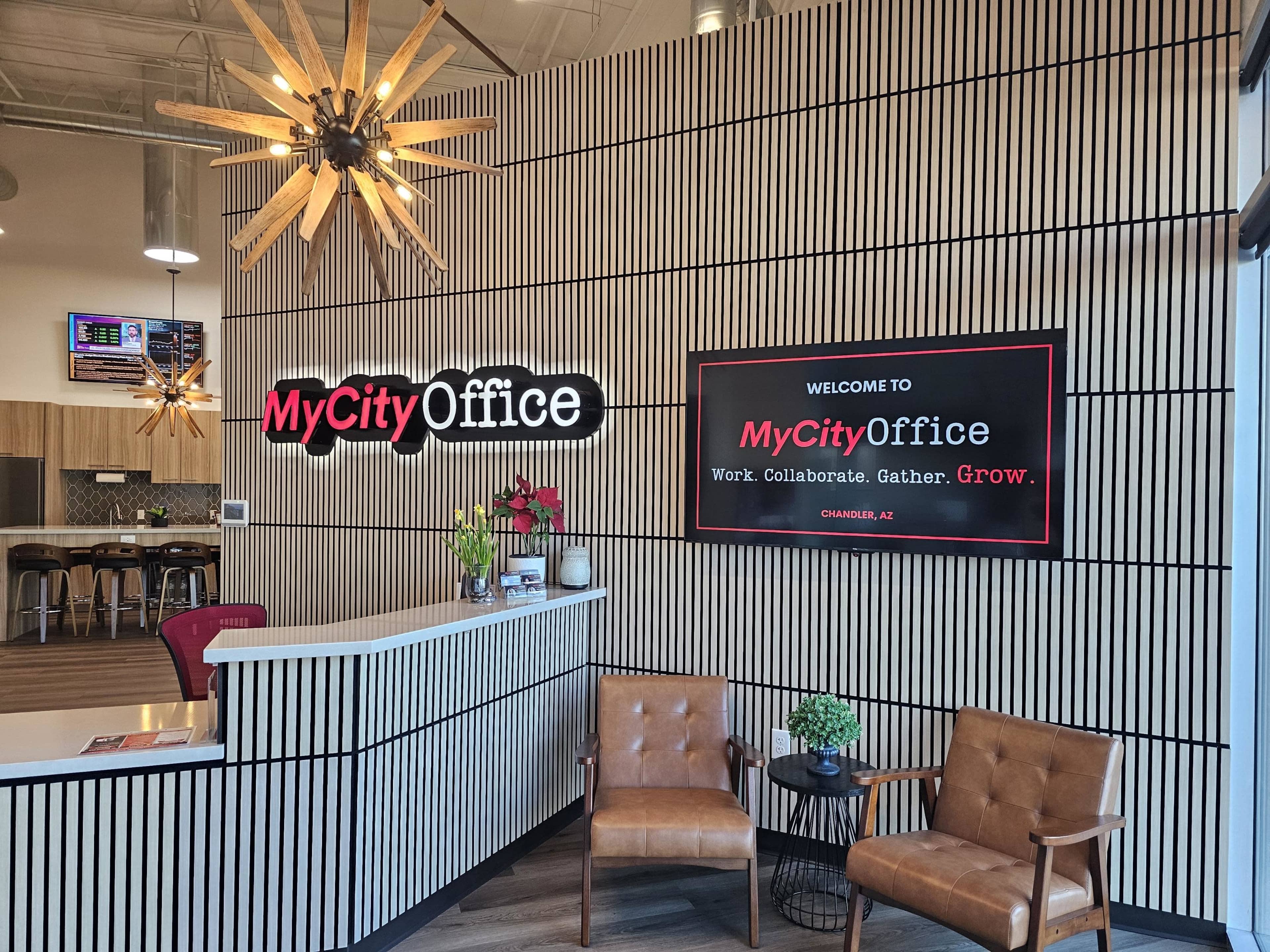 The image shows a modern office reception area featuring two brown chairs, a welcoming sign, and decorative wall paneling.