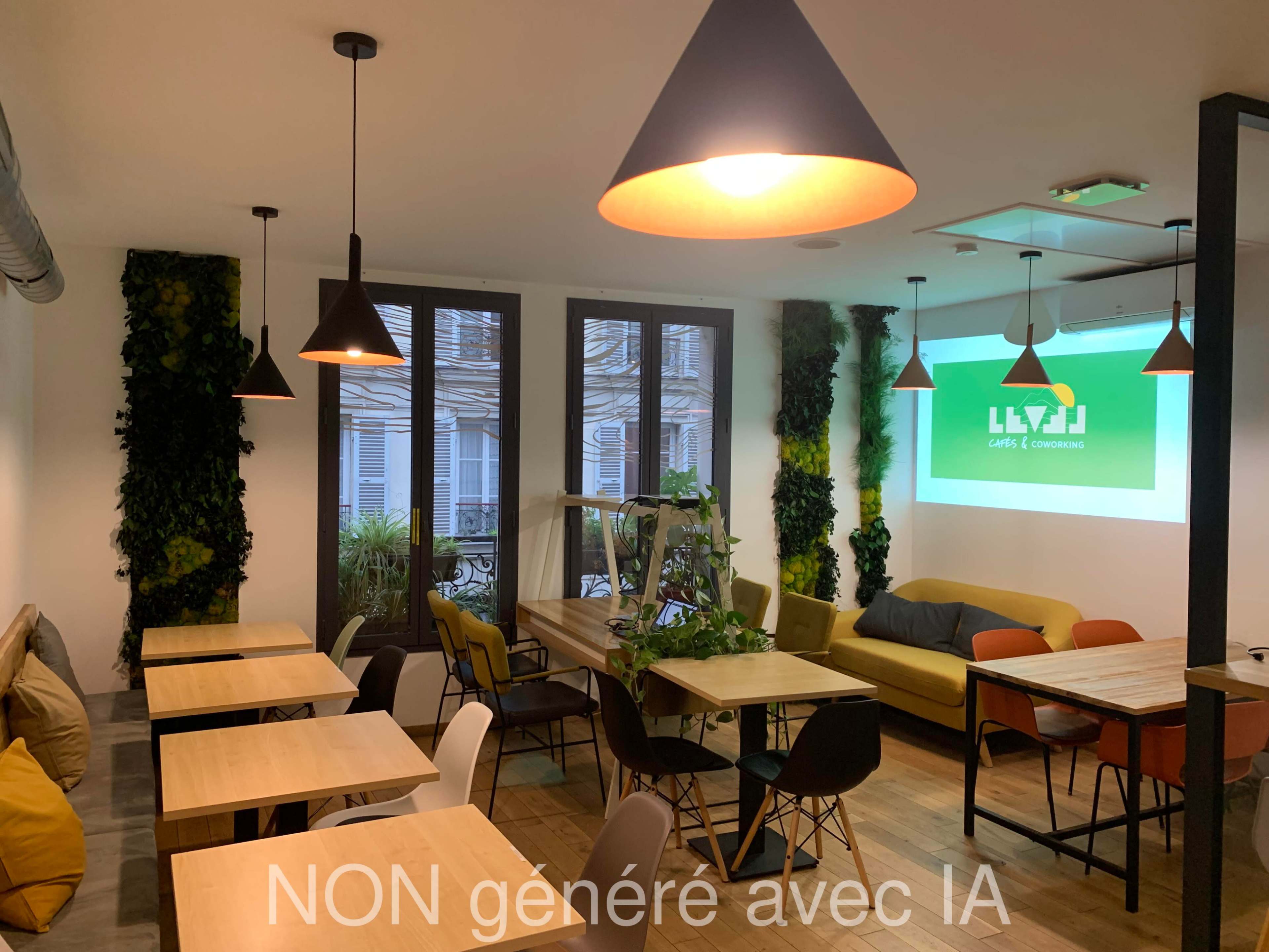 The image shows a cozy café with wooden tables, modern pendant lights, and greenery on the walls, featuring a large screen displaying the café's name.