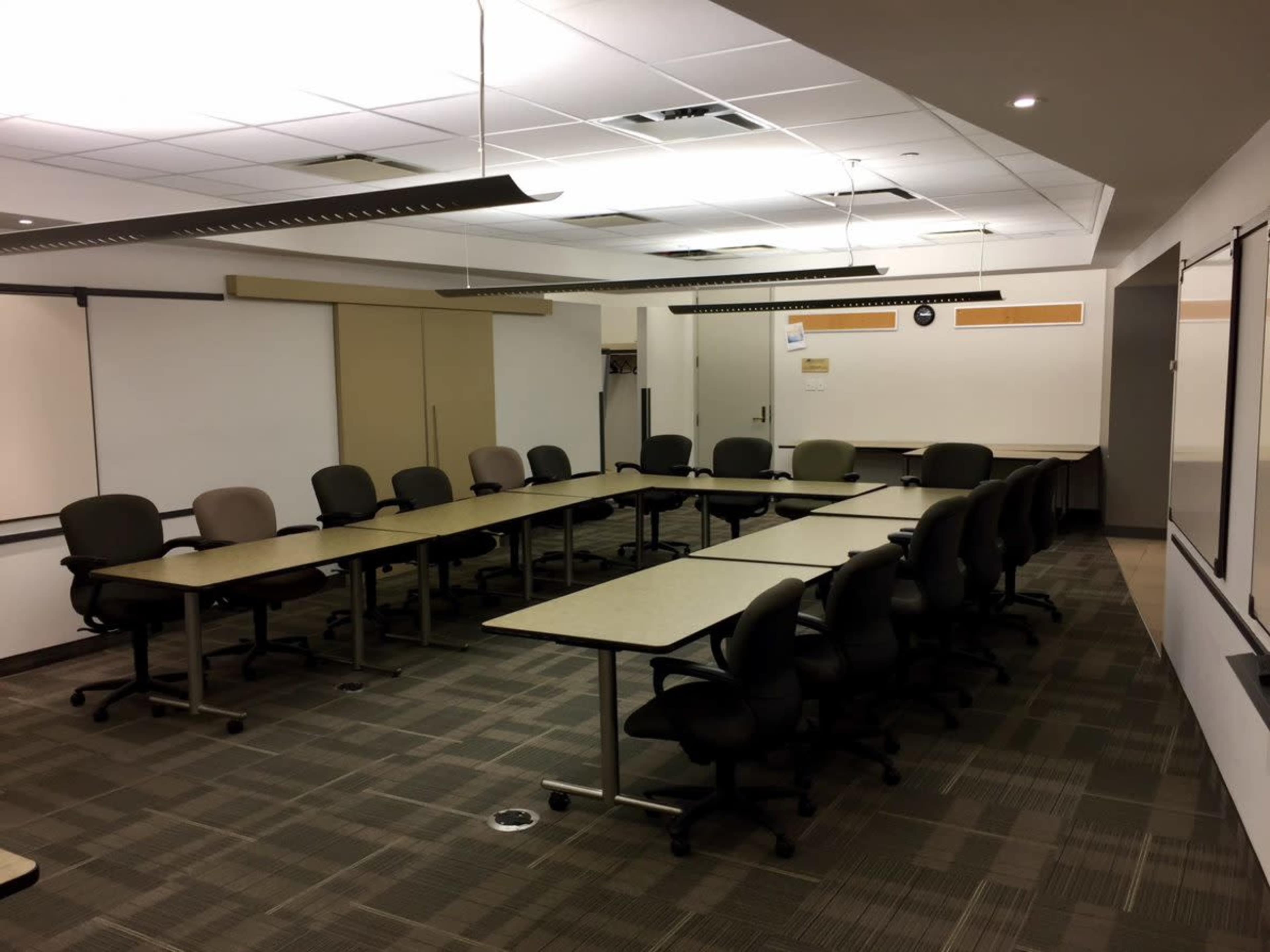 A large conference room with a rectangular arrangement of tables and chairs arranged around the perimeter.