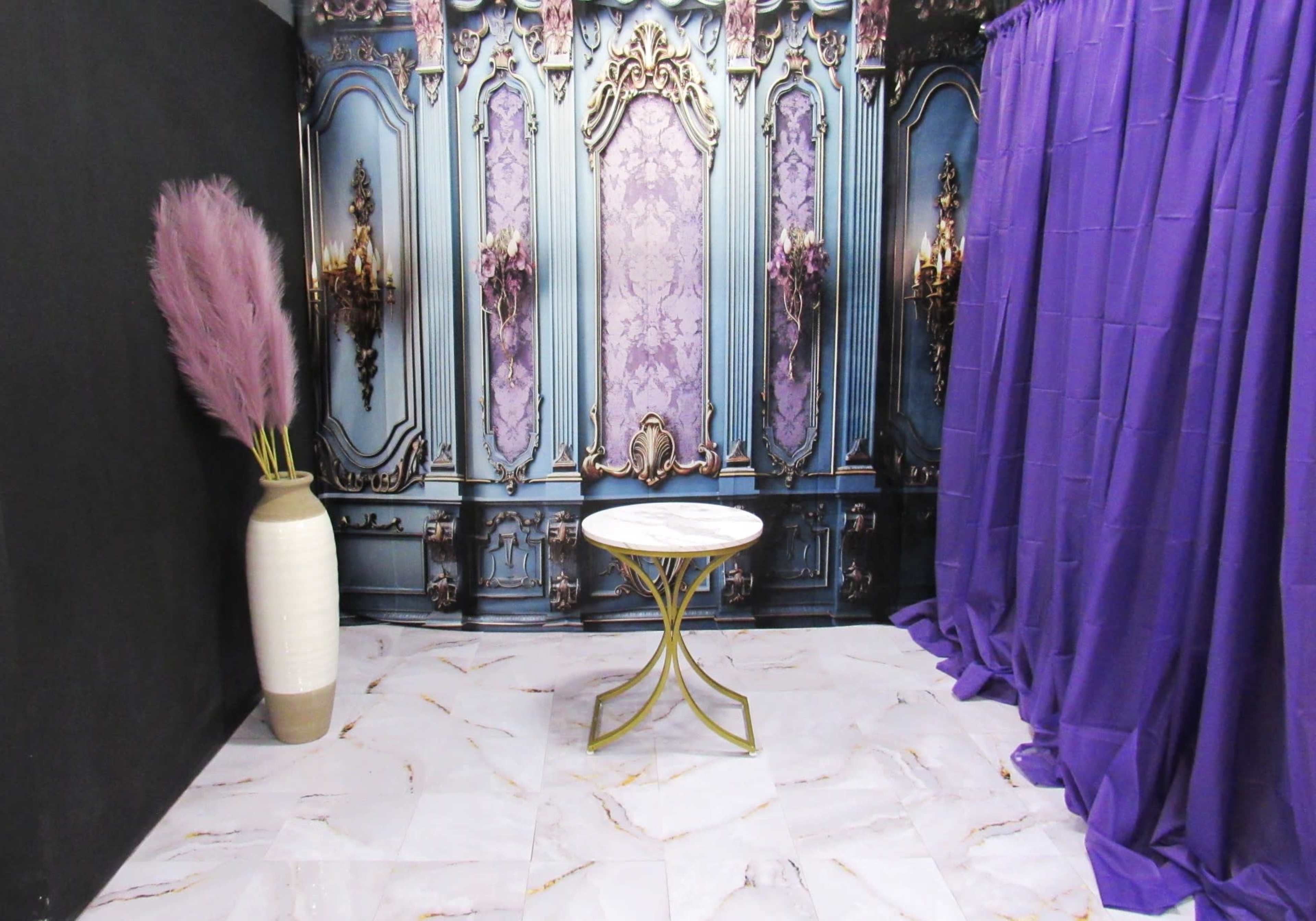 The image shows a room with a purple curtain, a marble table, and a decorative wall featuring an ornate design.