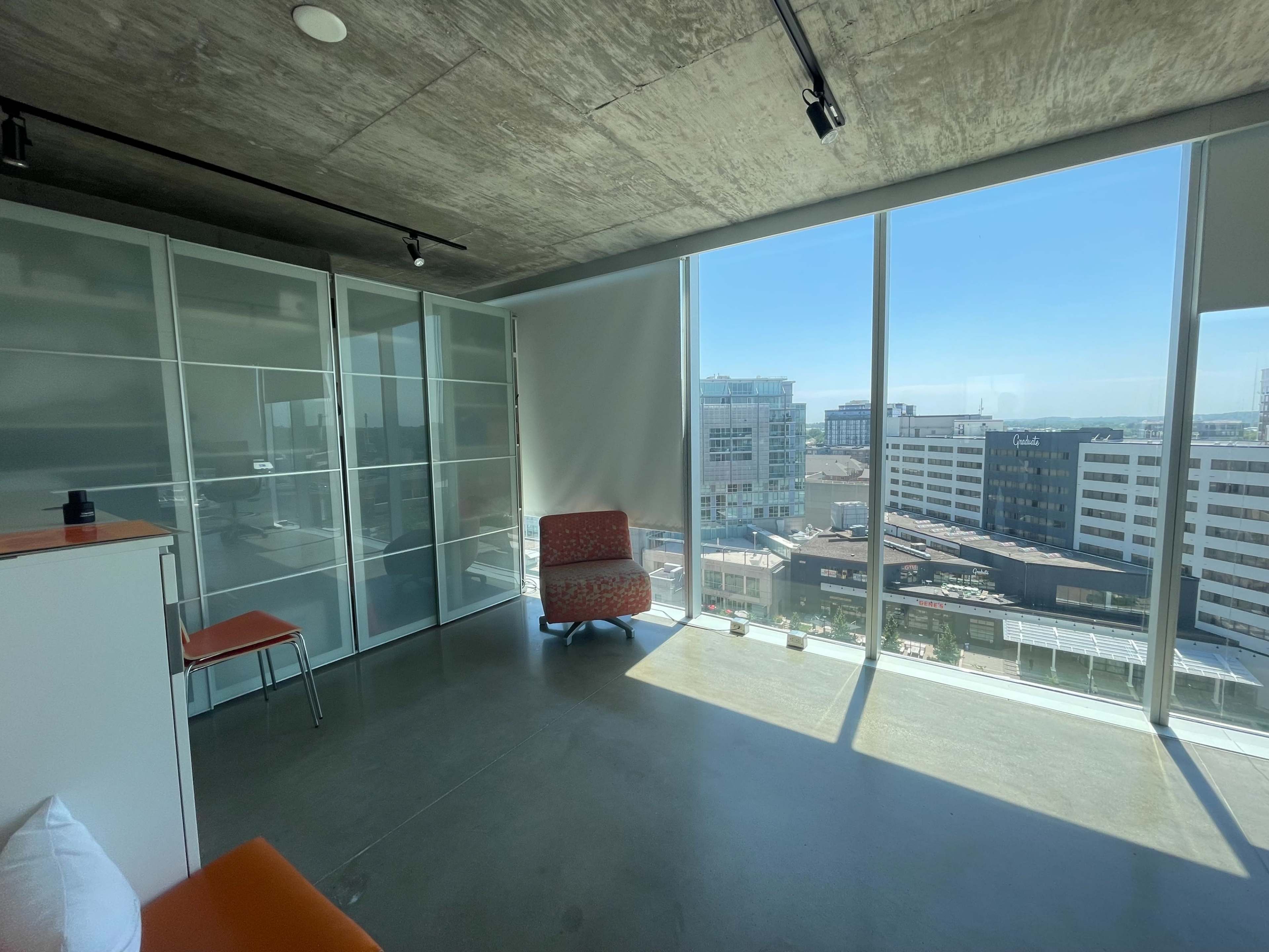 A modern, minimalistic office space with large windows and a view of a cityscape.