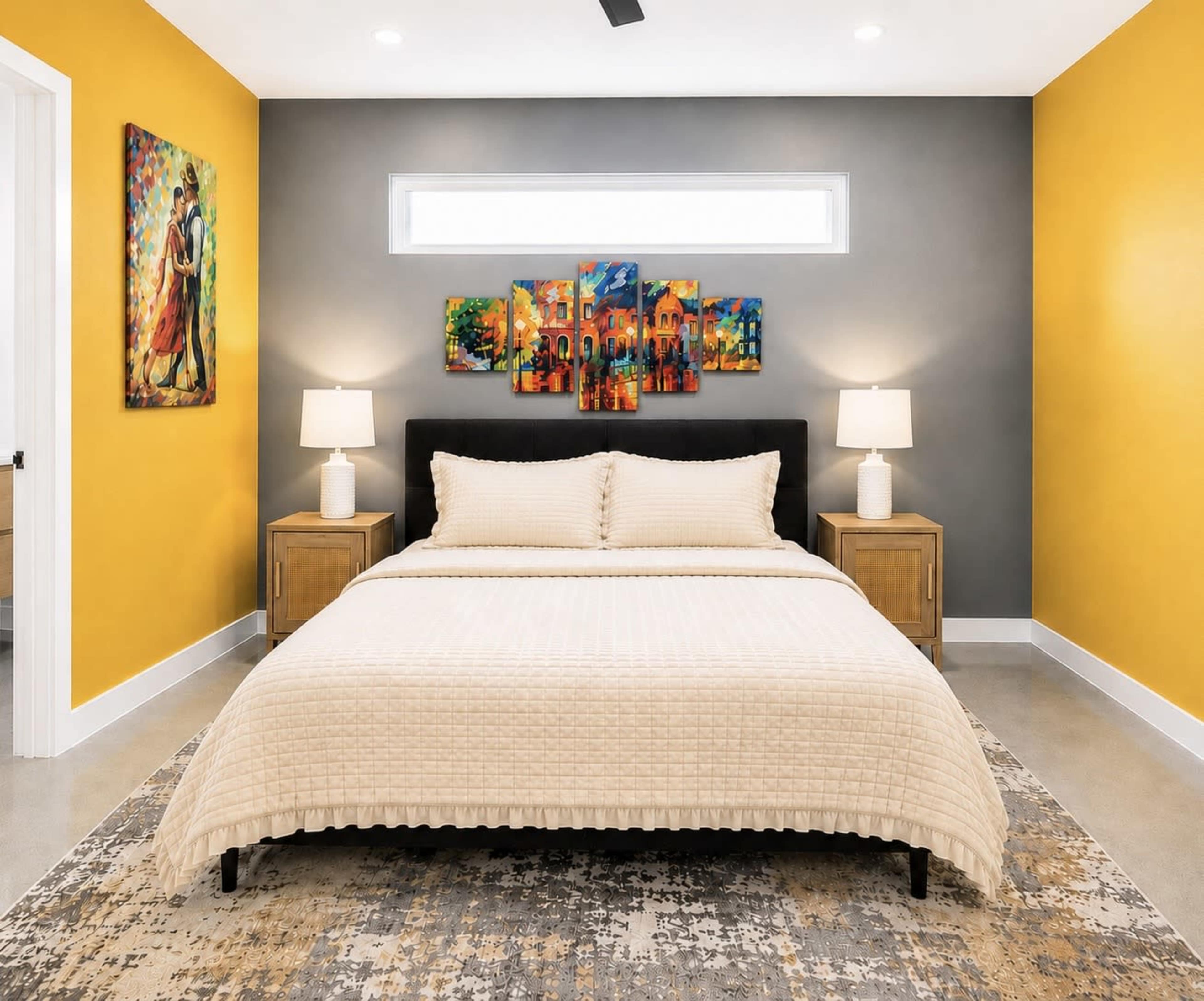 The image shows a modern bedroom with a large bed, nightstands on either side, colorful wall art, and bright yellow and gray walls.