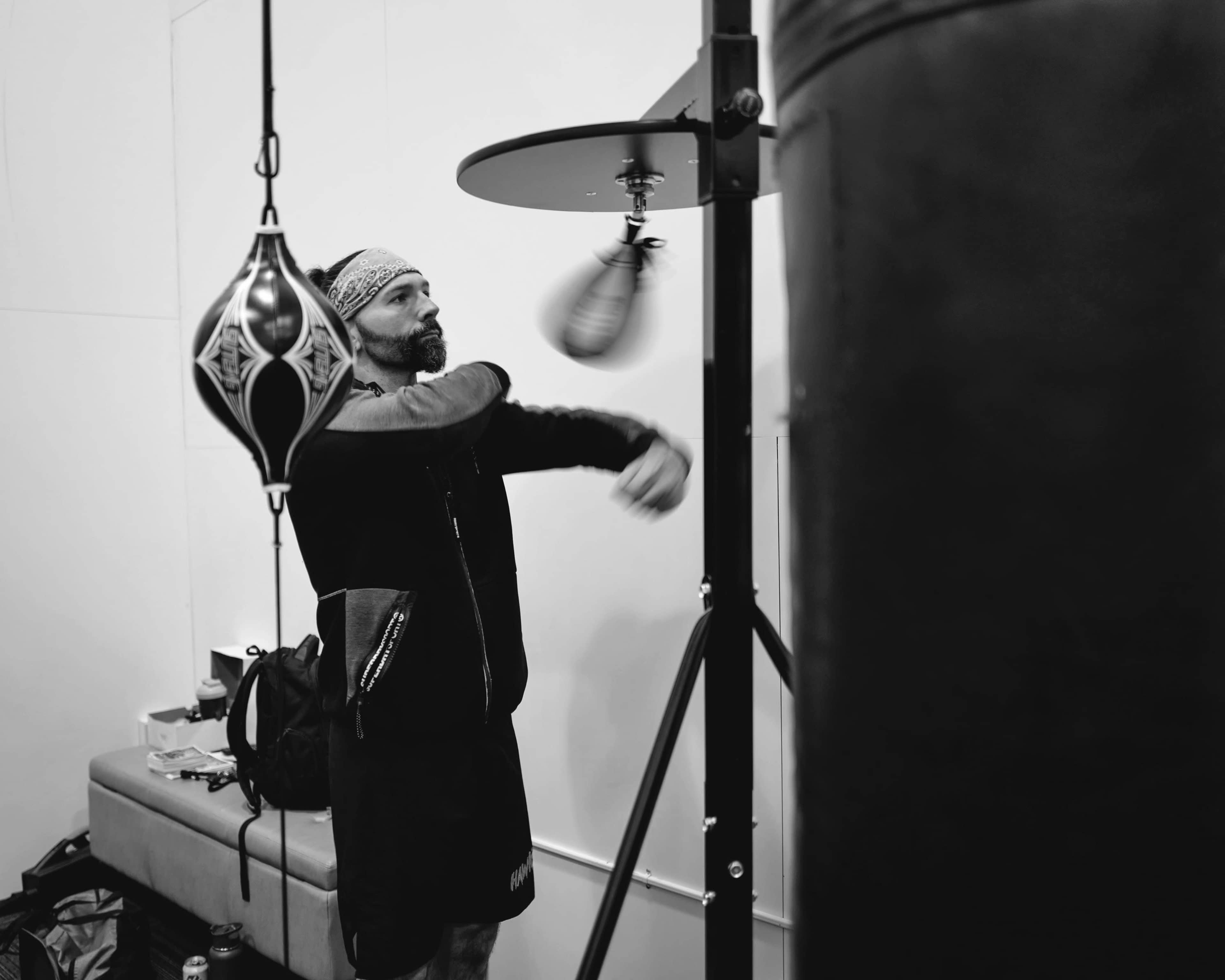 A person is practicing their punches on a speed bag in a gym setting.