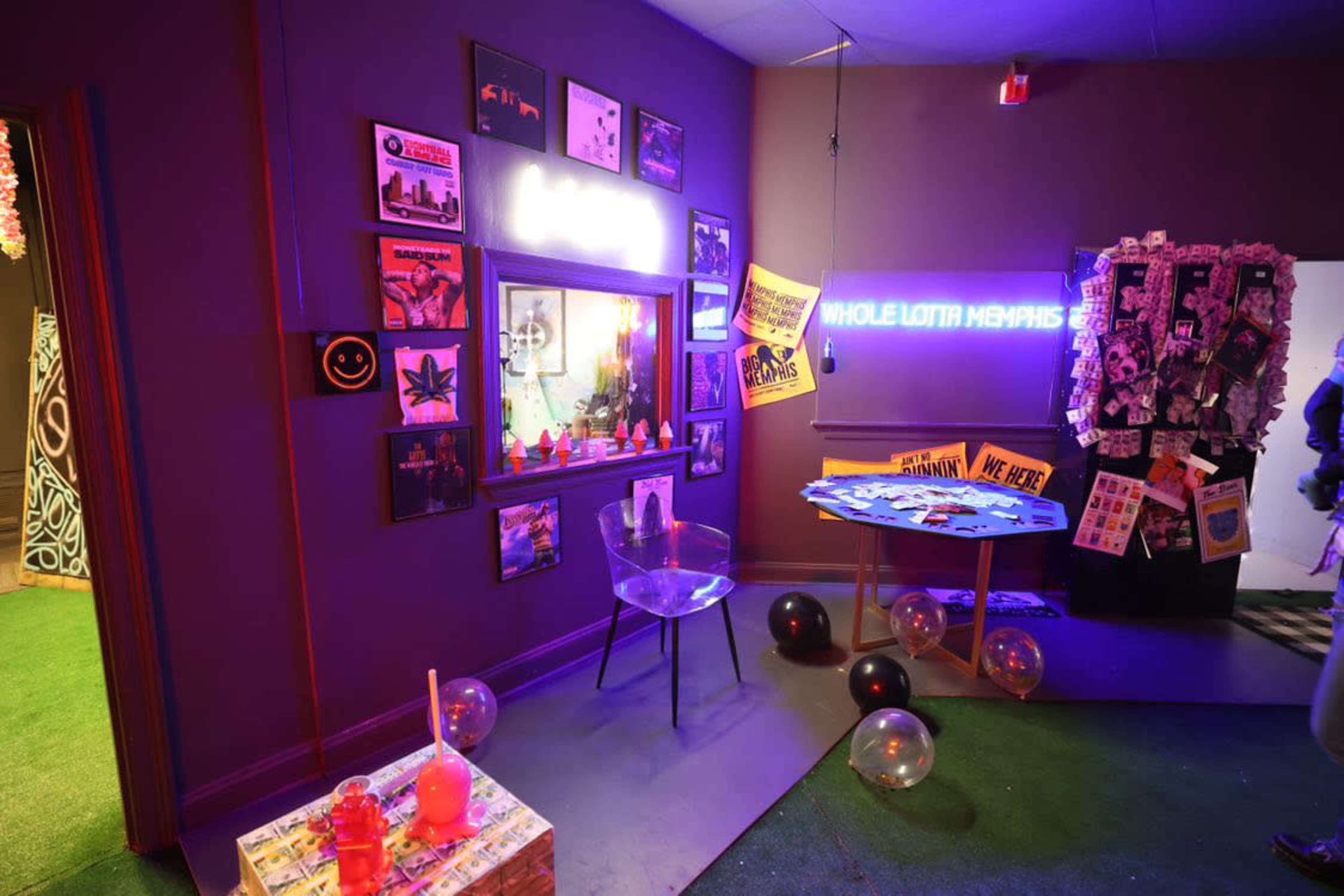 The room features a vibrant decor with neon signs, posters, and a clear chair, creating a lively atmosphere.