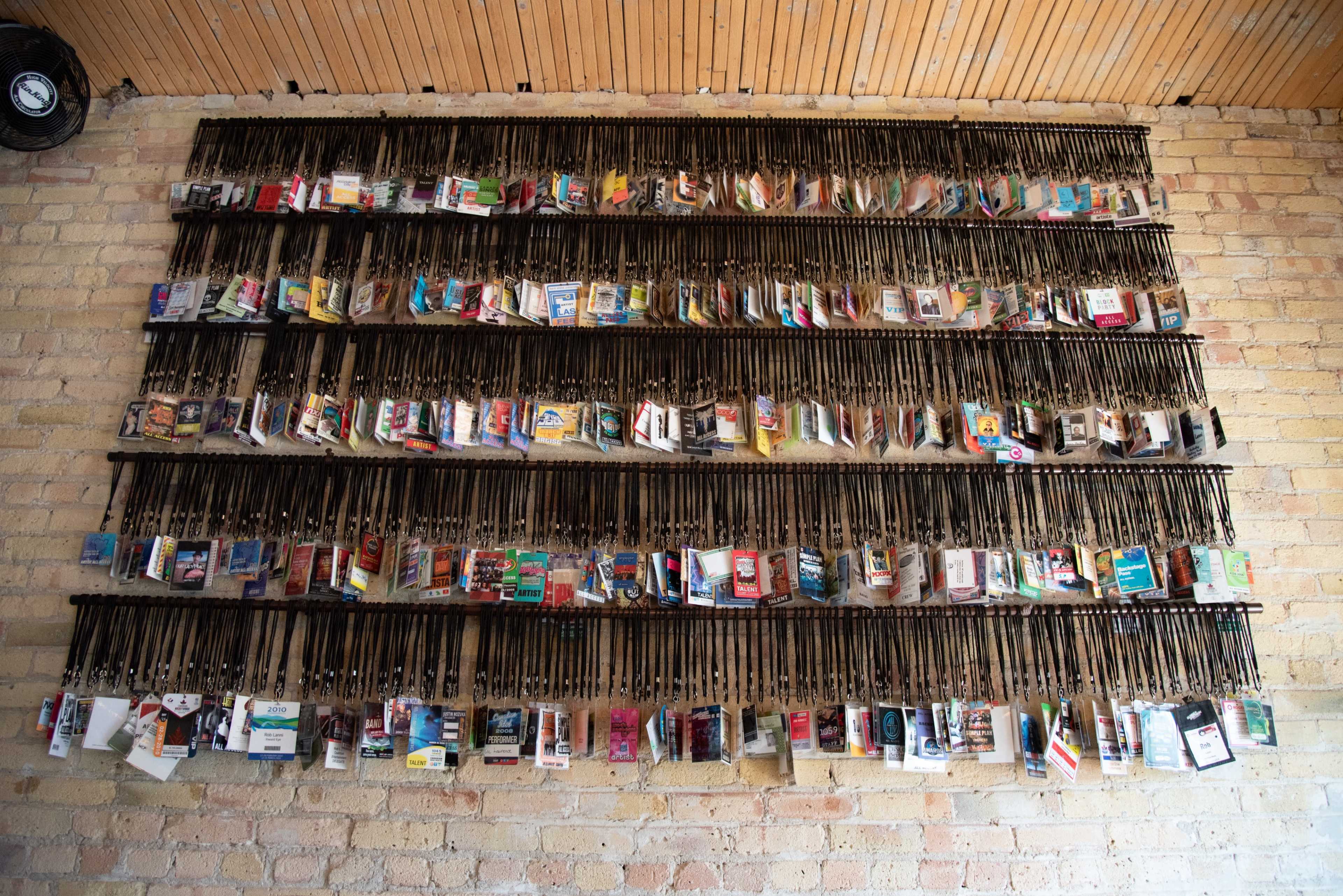 A wall displays an array of postcards and brochures, organized in a grid on metal clips.