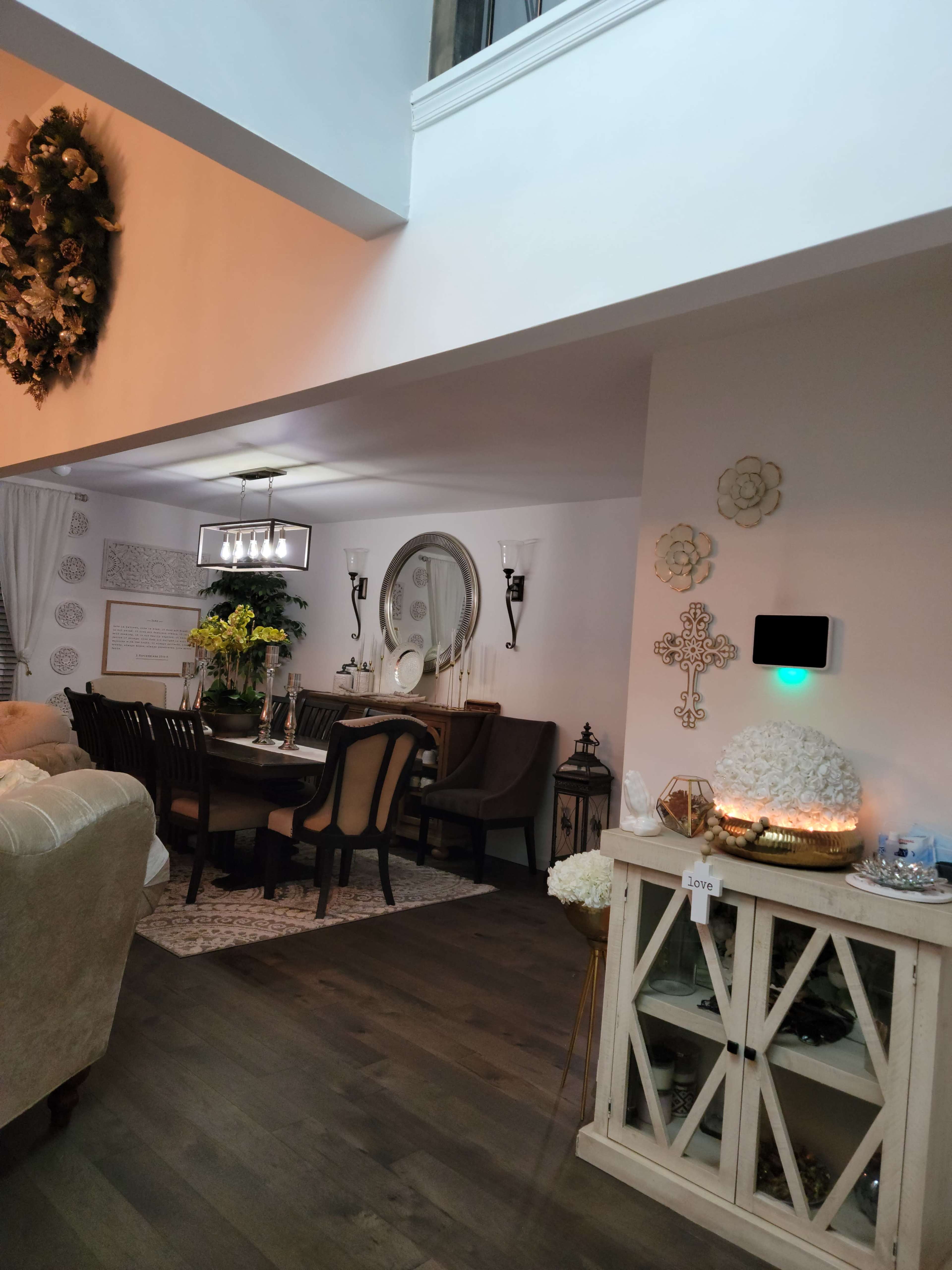 A well-furnished dining area with a wooden table, surrounded by chairs, and an adjacent living area featuring a sofa and decorative items.