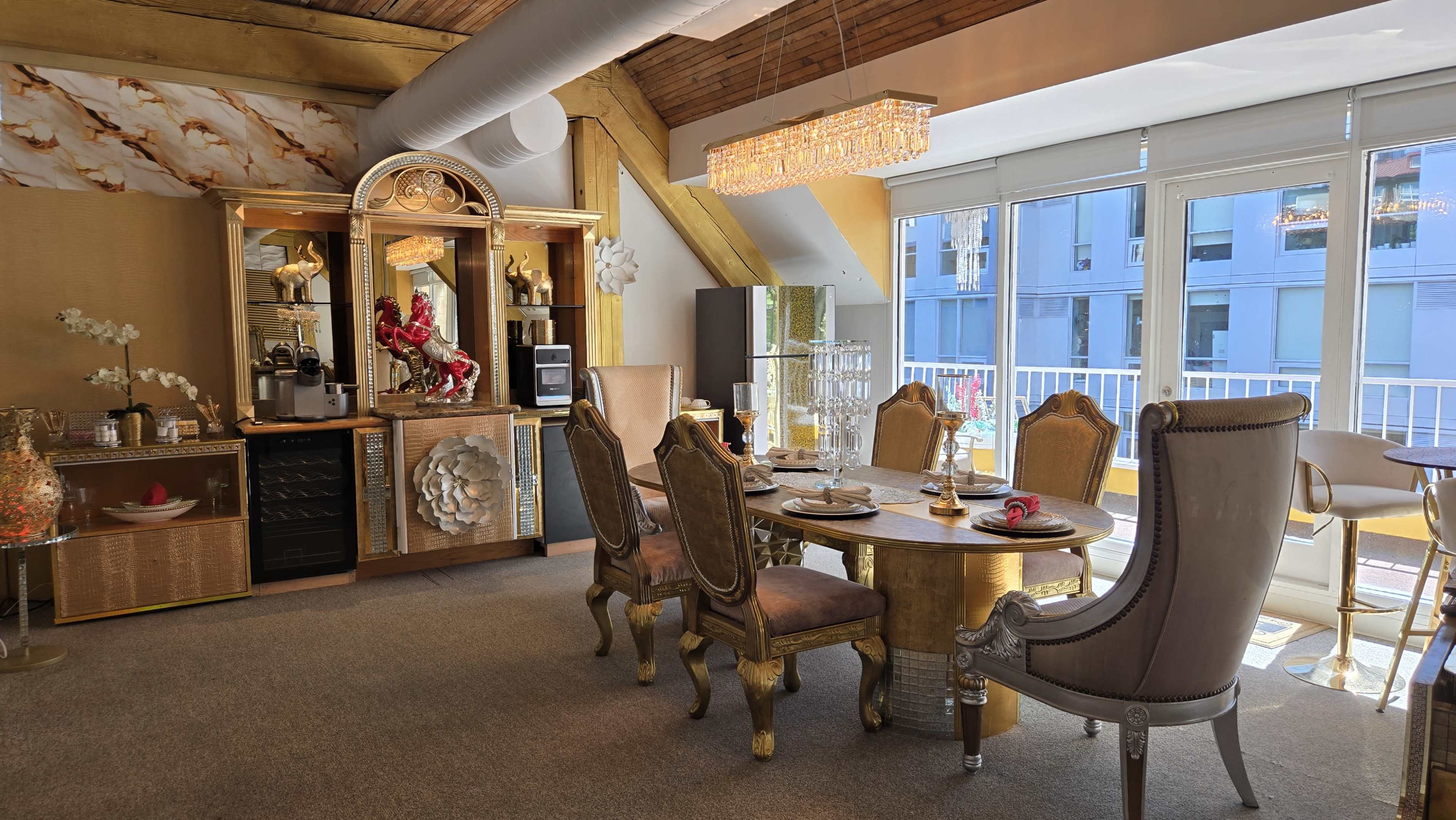 A dining area features an ornate table surrounded by elegant chairs, with a decorative cabinet and a large window providing natural light.