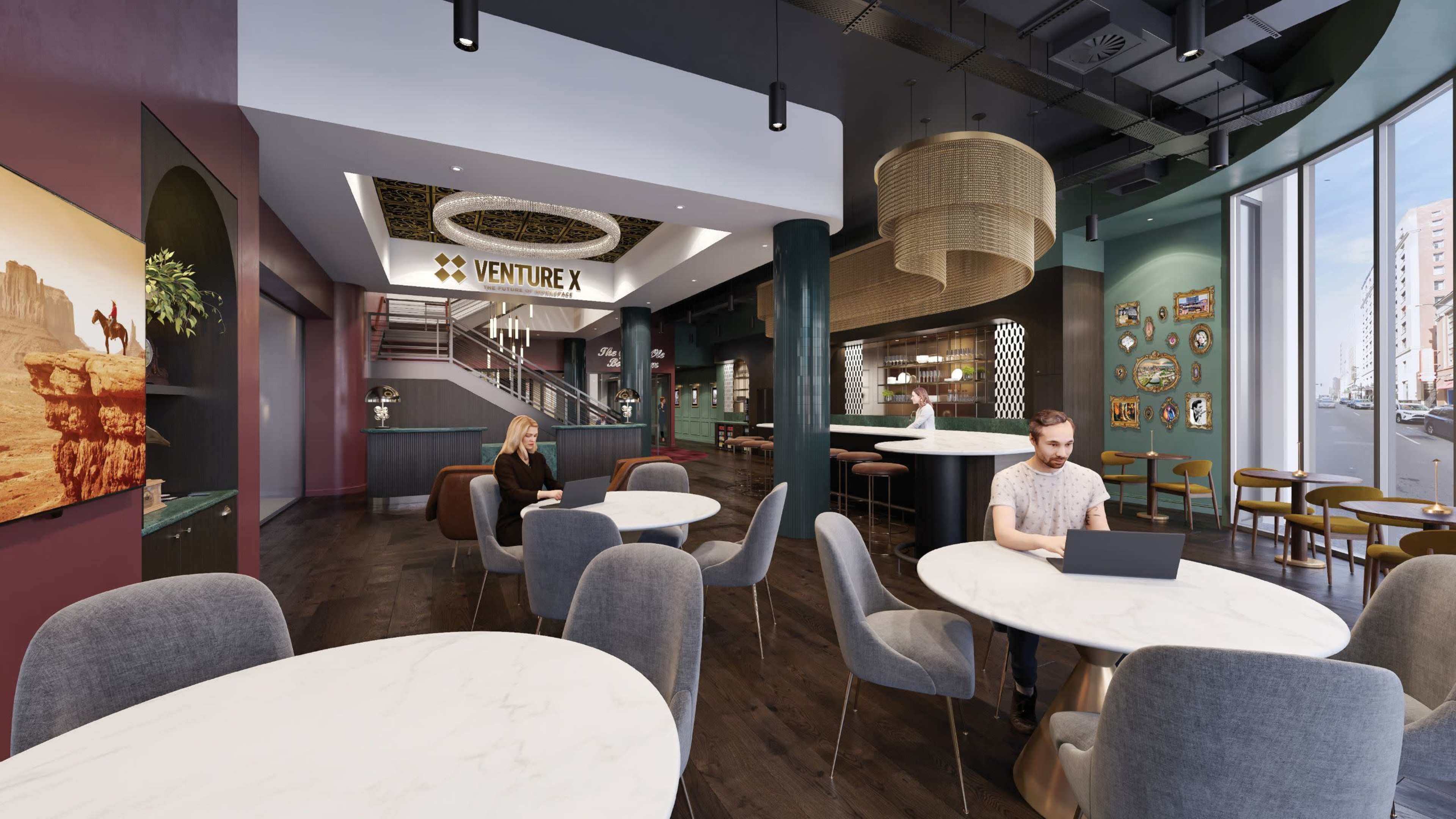 The image shows a modern coworking space with a variety of seating arrangements, including tables and chairs, and a reception area featuring a large sign for "Venture X."