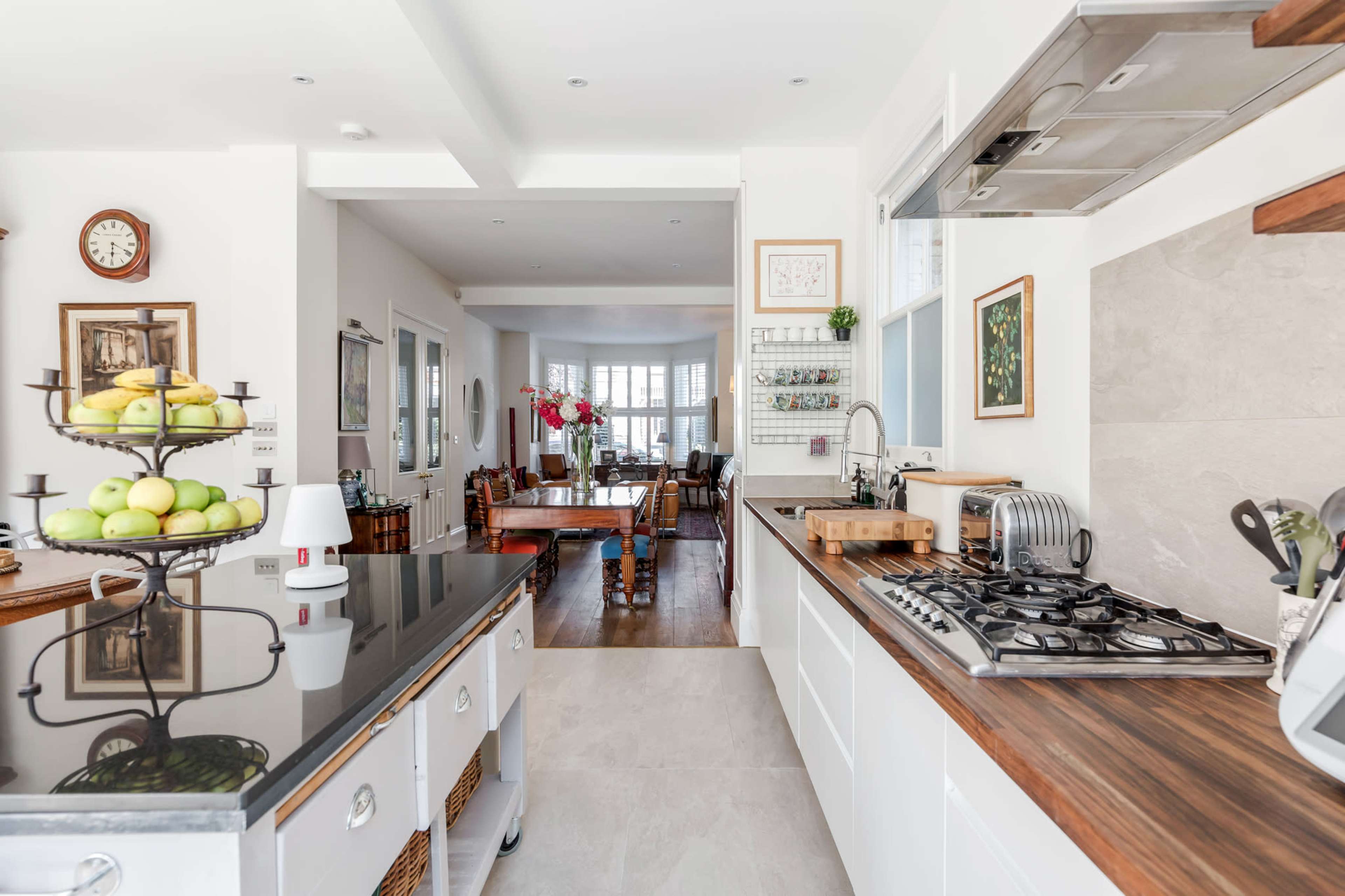 A modern kitchen with a central island, featuring a gas stove, and an adjacent dining area visible through an open layout.