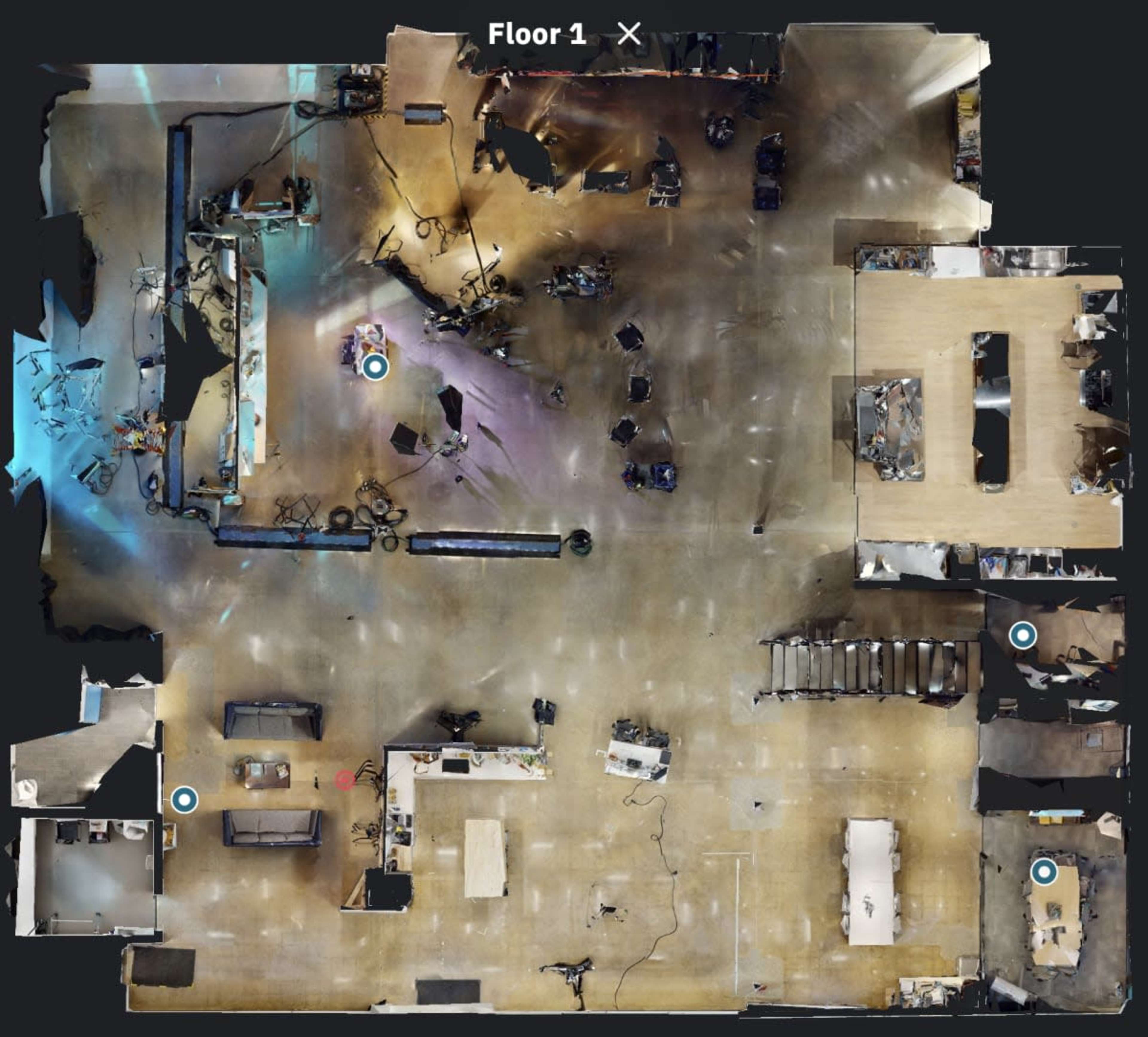 A top-down view of a floor plan with various workstations, furniture, and equipment laid out across the space.