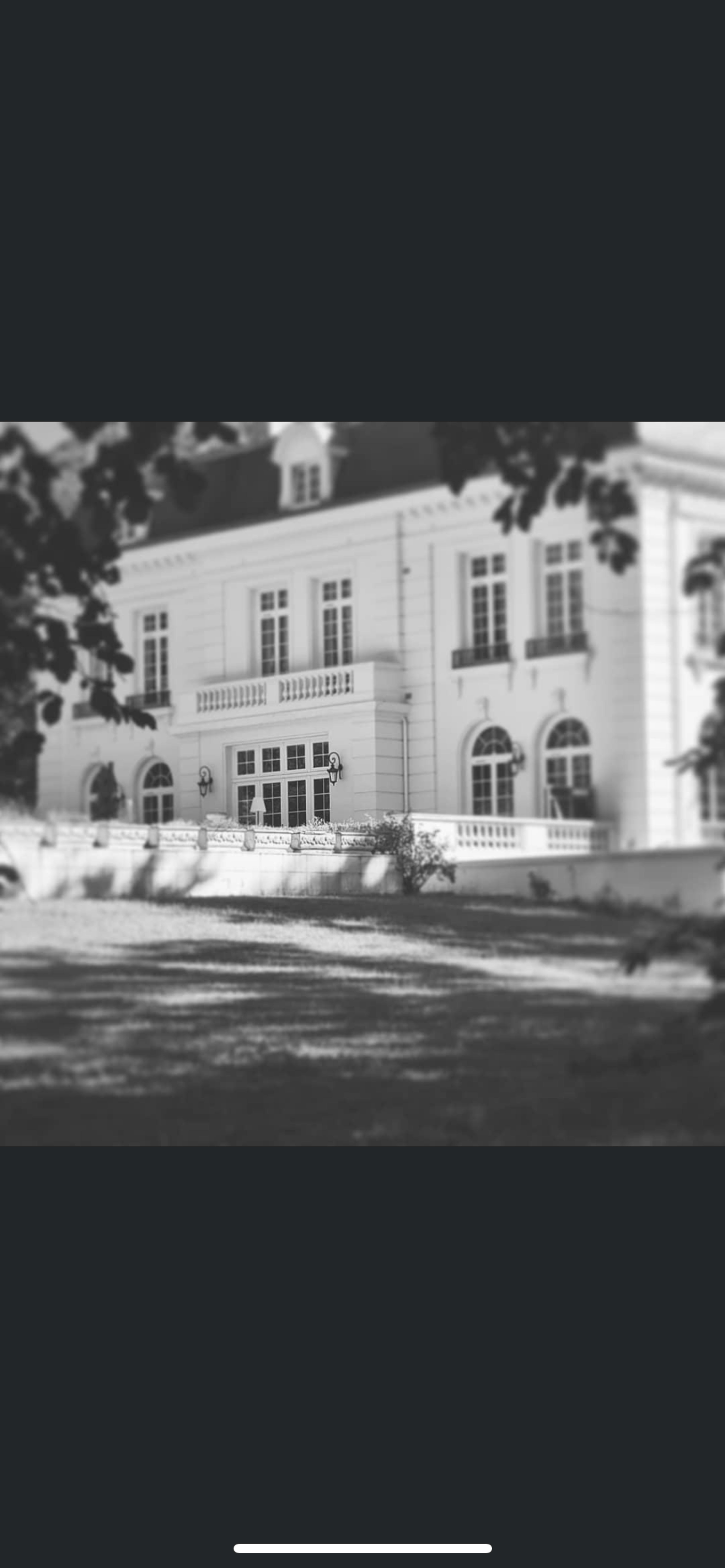 A large, elegant white mansion set against a backdrop of greenery.