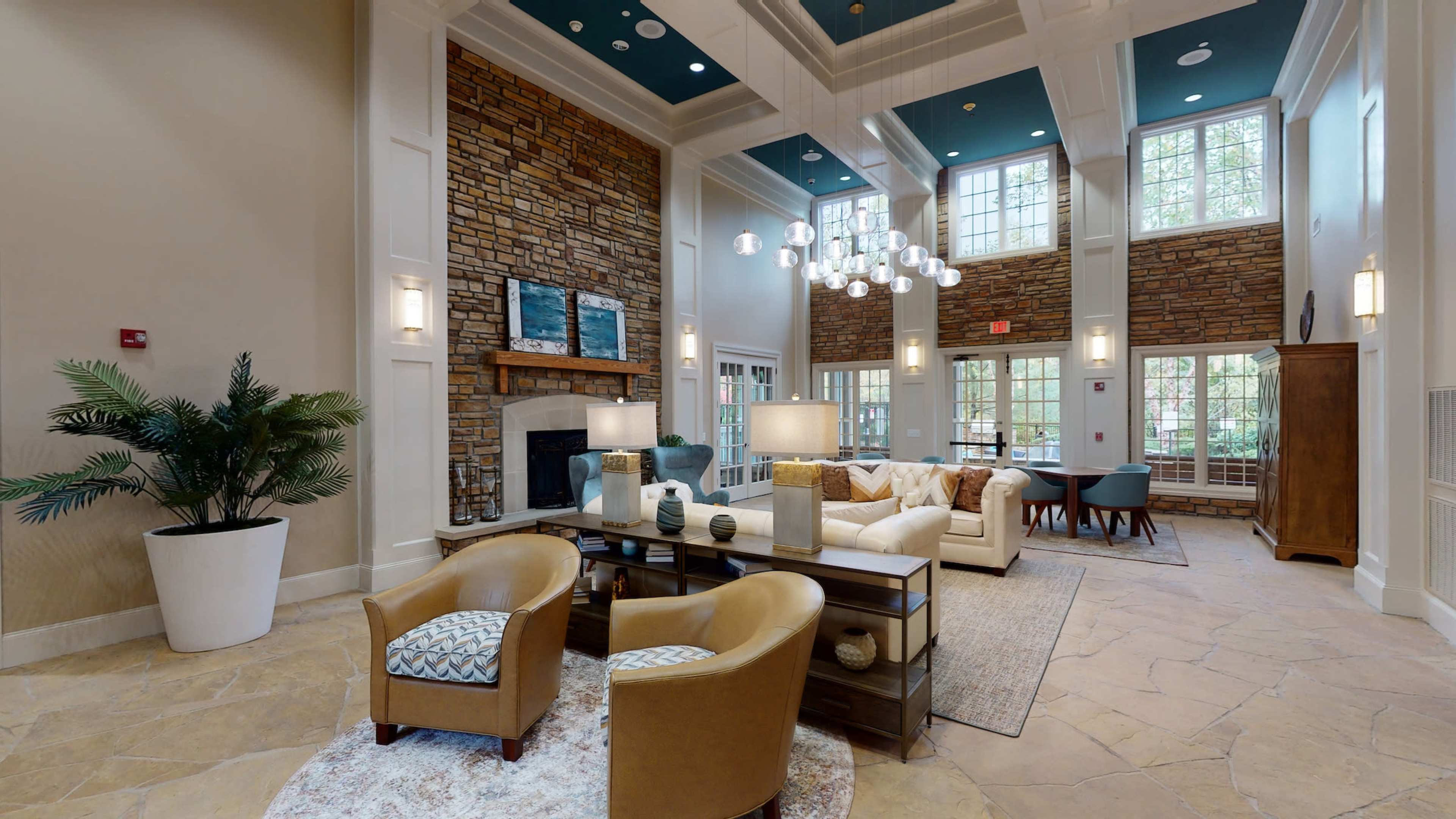A spacious lobby with a stone fireplace, contemporary seating areas, and large windows allowing natural light to enter.