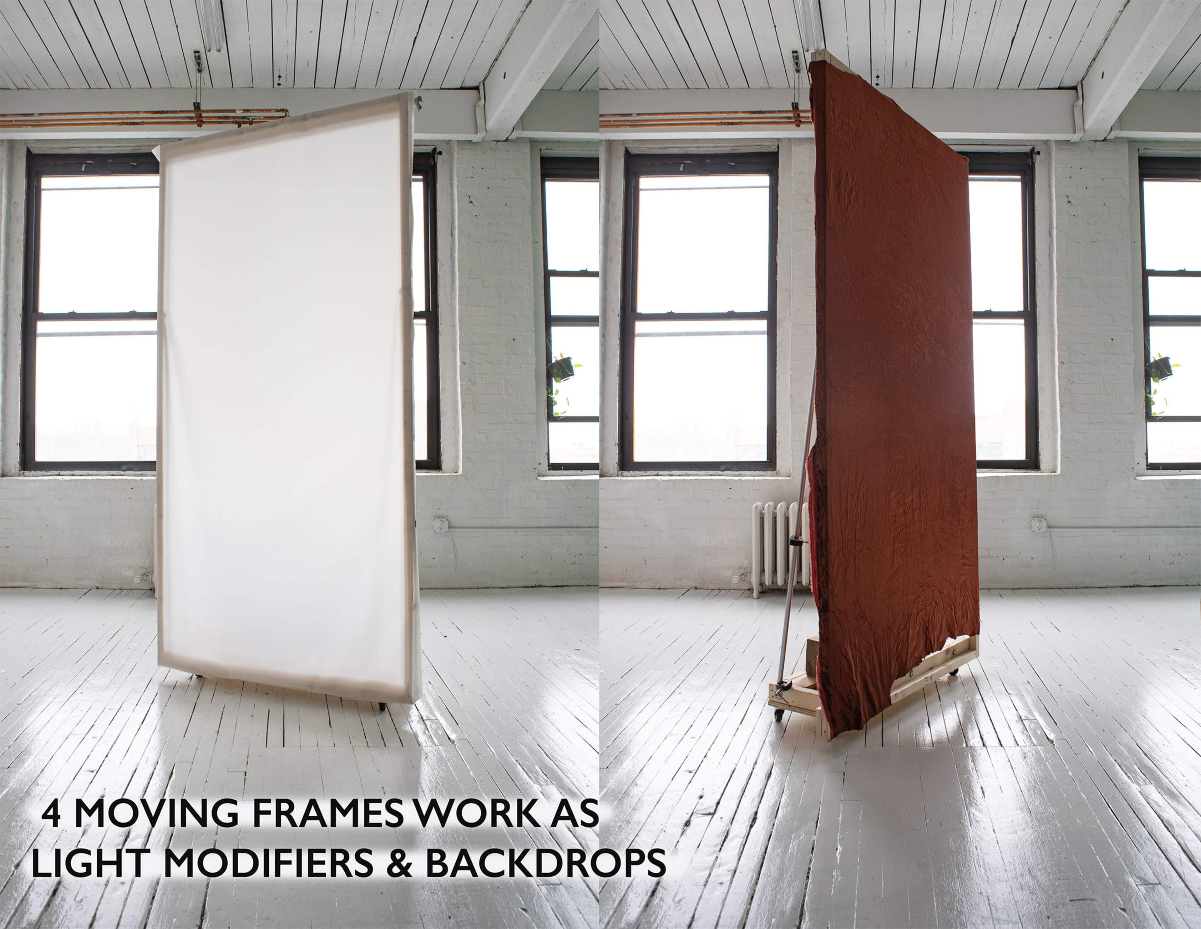 Two movable frames in a studio setting, one covered with a white fabric and the other with a reddish-brown fabric, positioned near large windows.