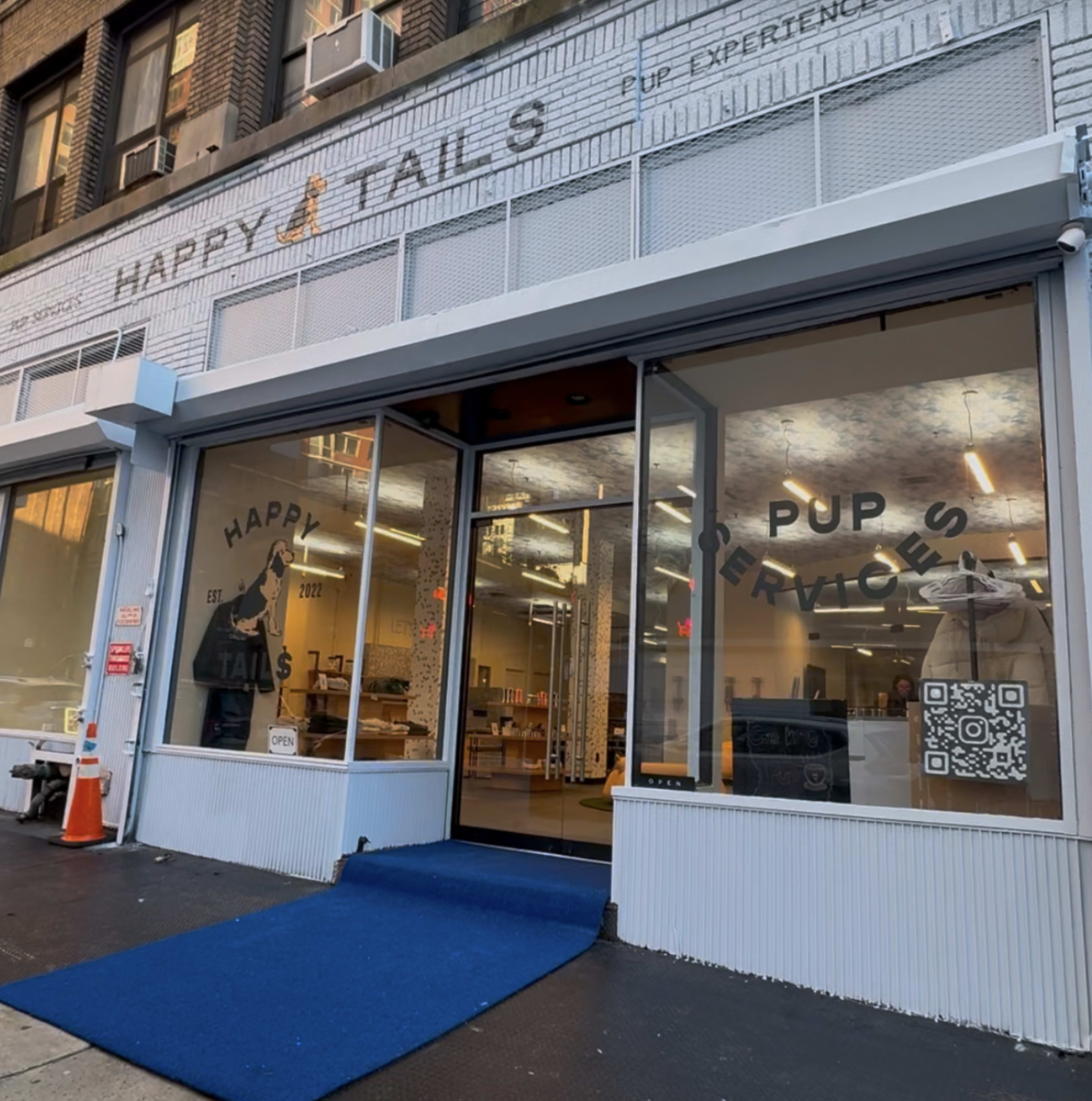 The image shows the storefront of "Happy Tails," a business focused on services for dogs, with large windows displaying the name and a QR code.