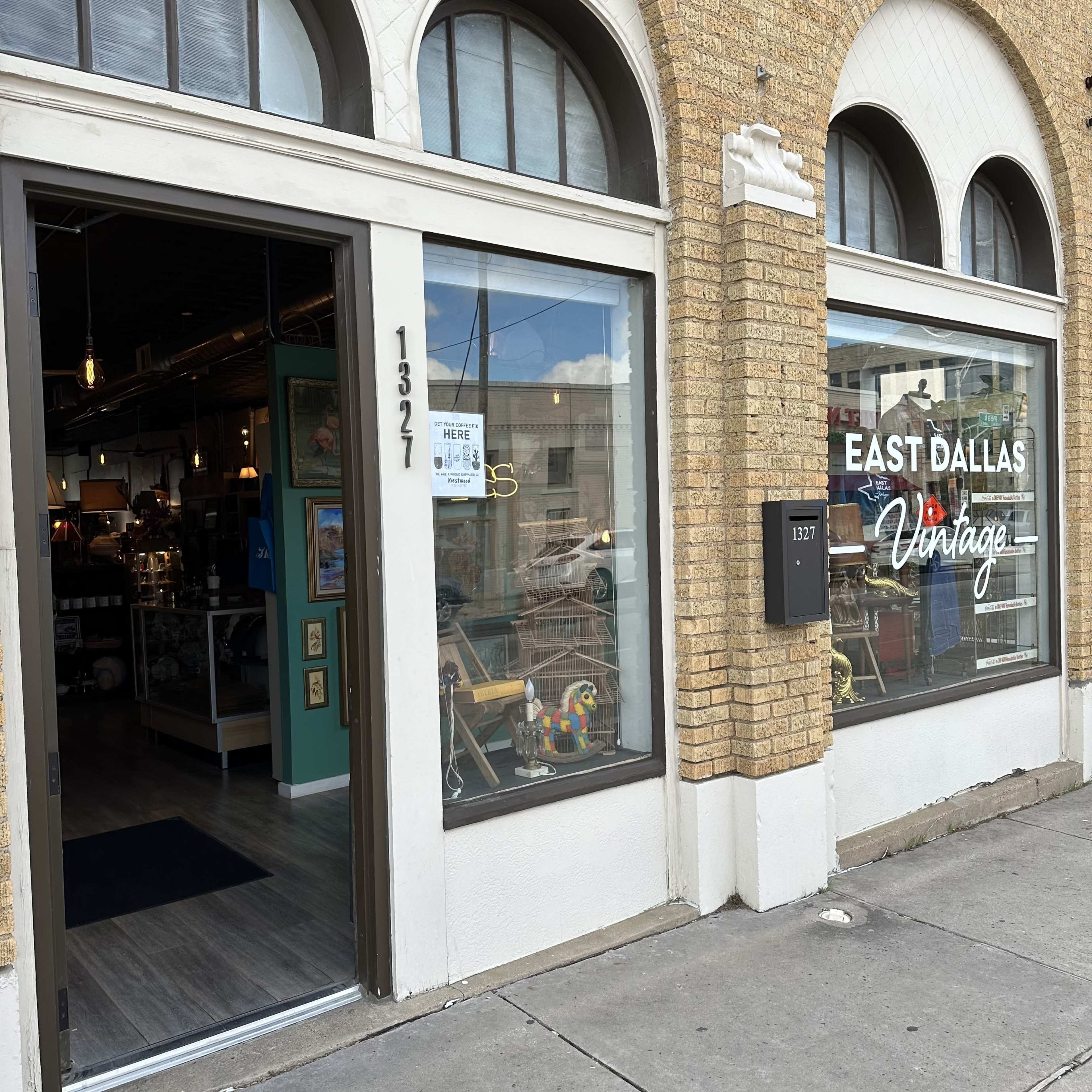 The storefront of East Dallas Vintage features large windows showcasing various antique and vintage items inside.