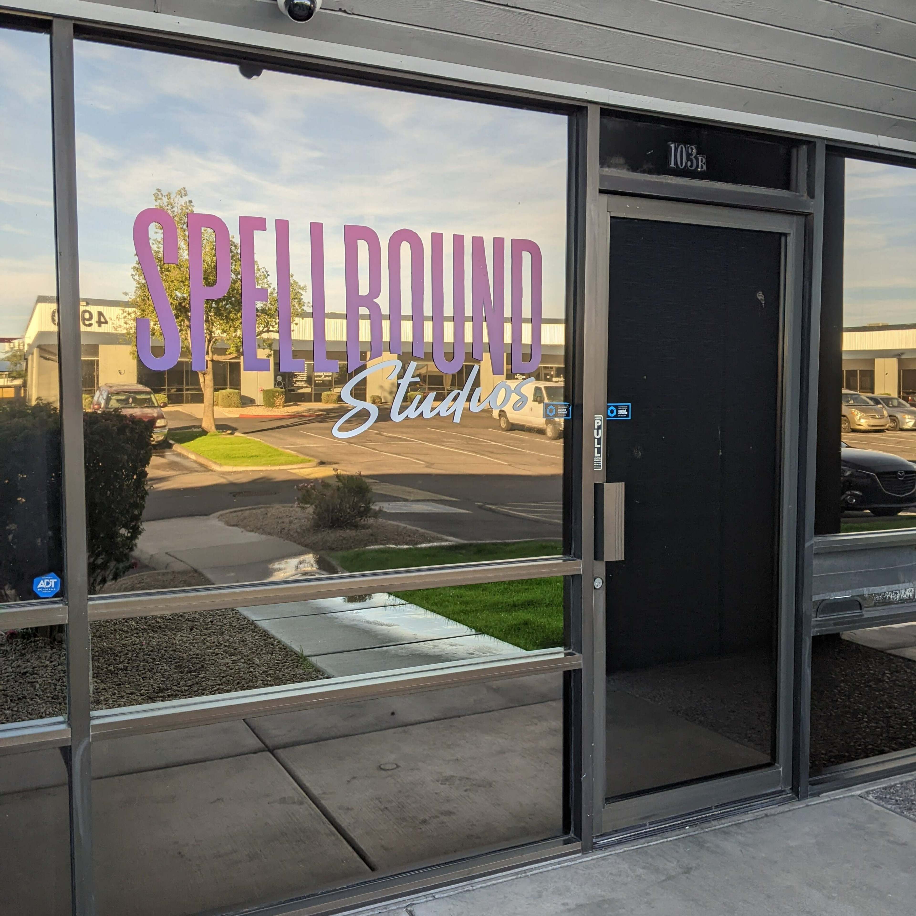 The entrance of Spellbound Studios, featuring large lettering on a glass window and a door leading into the building.