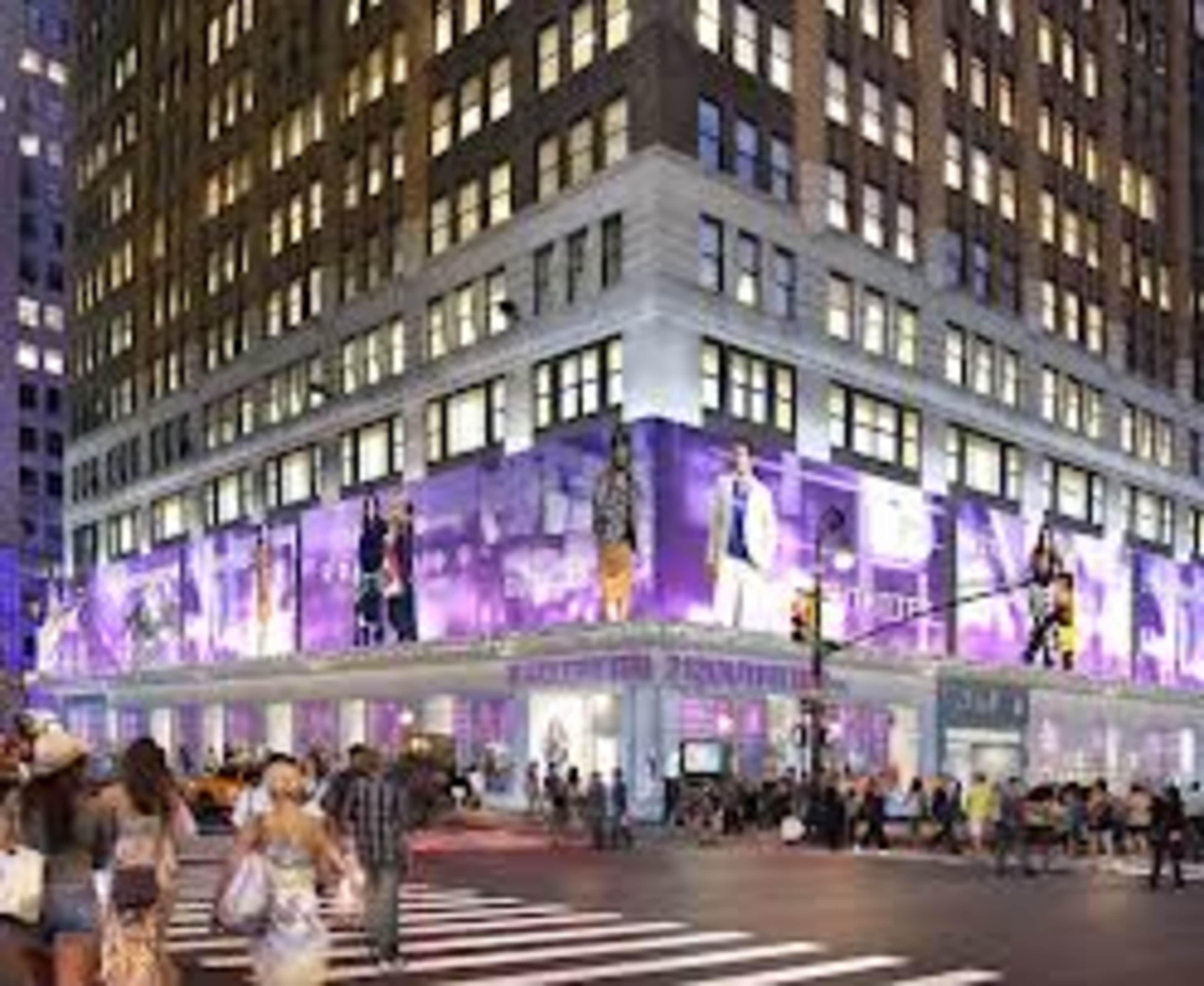 The image shows a large building corner adorned with colorful advertisements and illuminated displays in an urban setting.