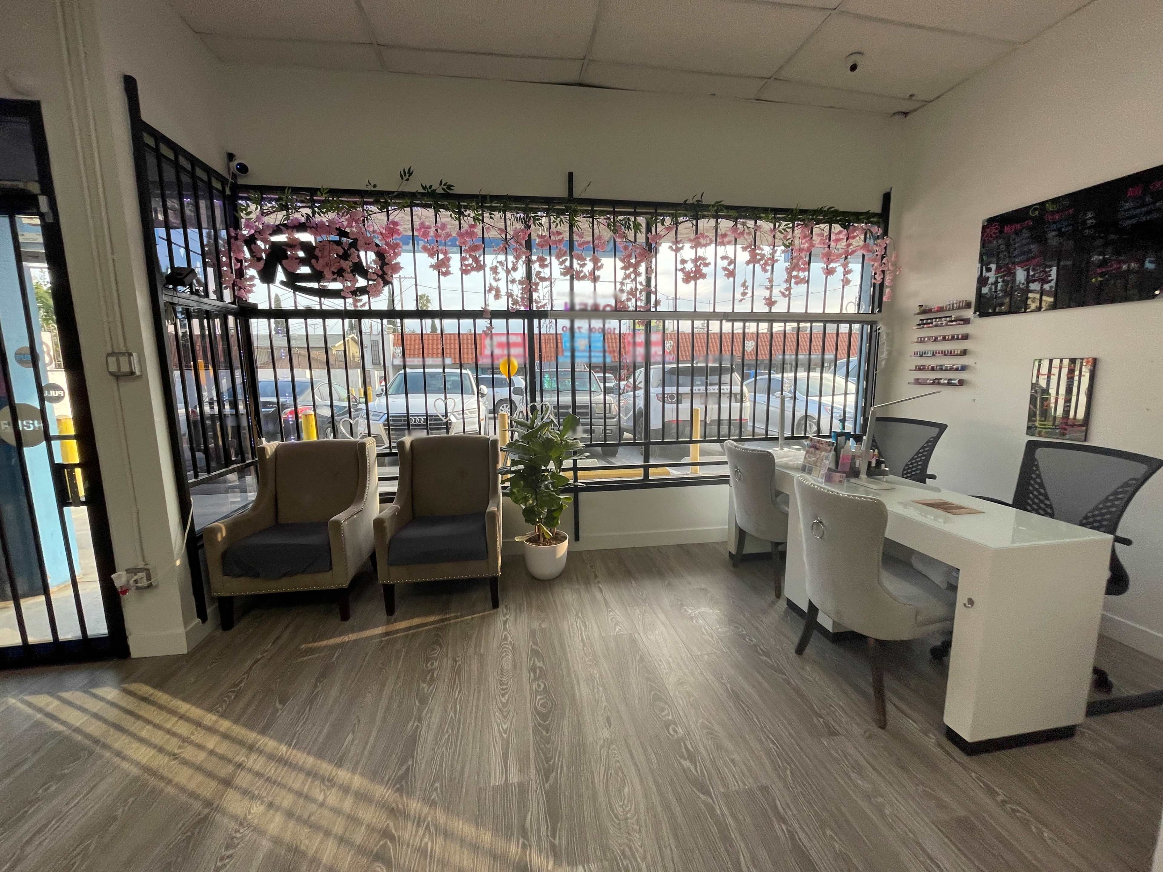 A salon interior with two chairs, a table, and a large window adorned with floral decorations.