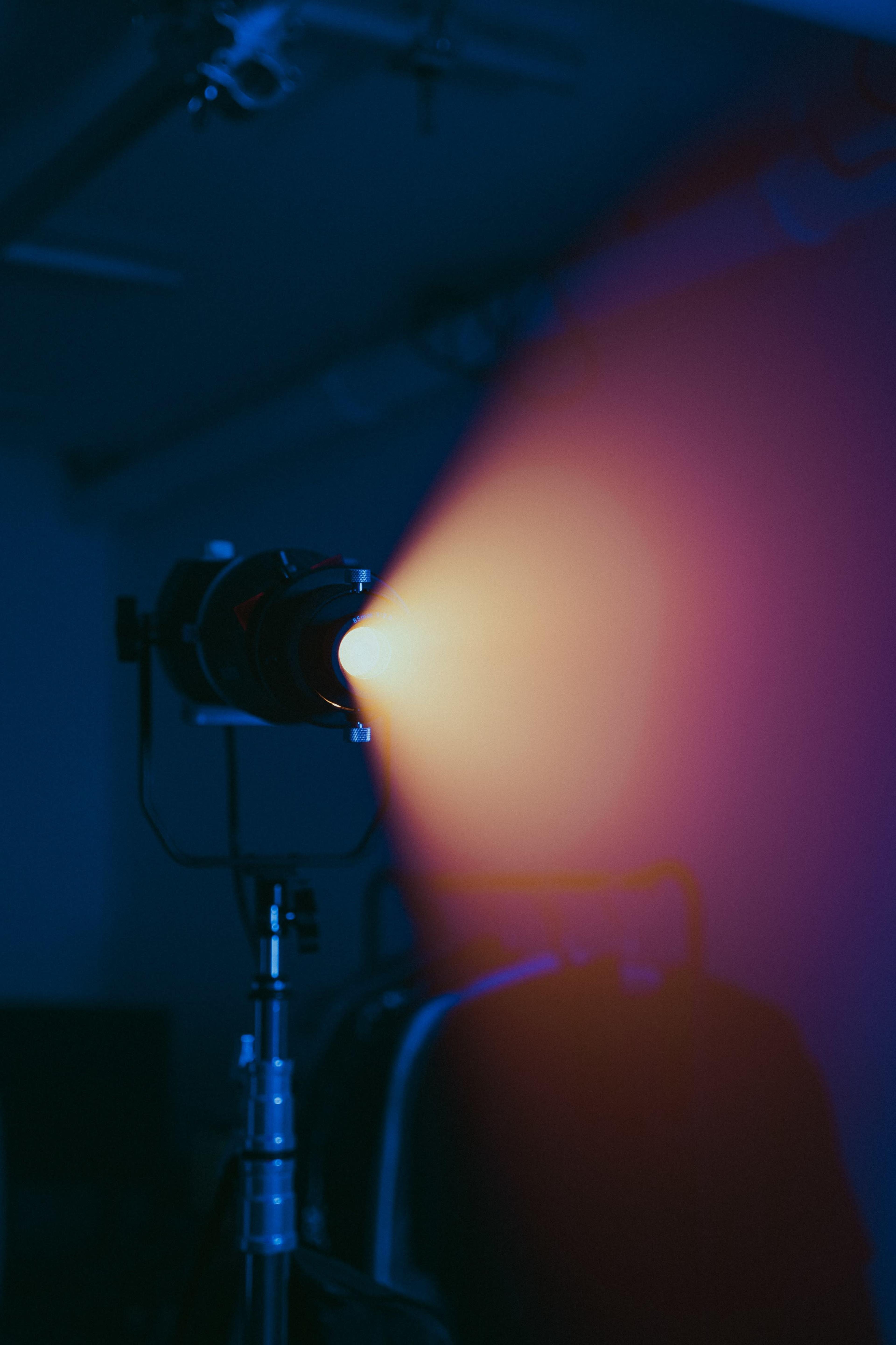 A spotlight emits a beam of light in a dimly lit room.