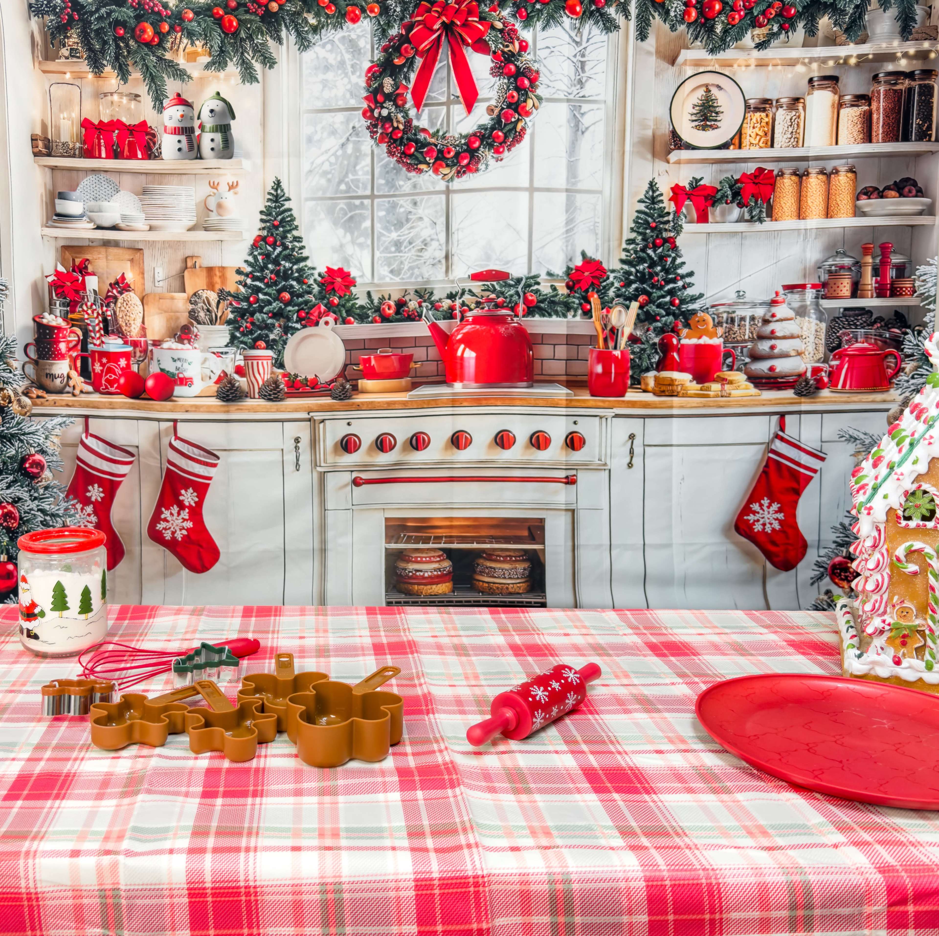 A festive kitchen scene features a decorated countertop with red cooking utensils, holiday-themed decor, and a backdrop of a pine garland and stockings.