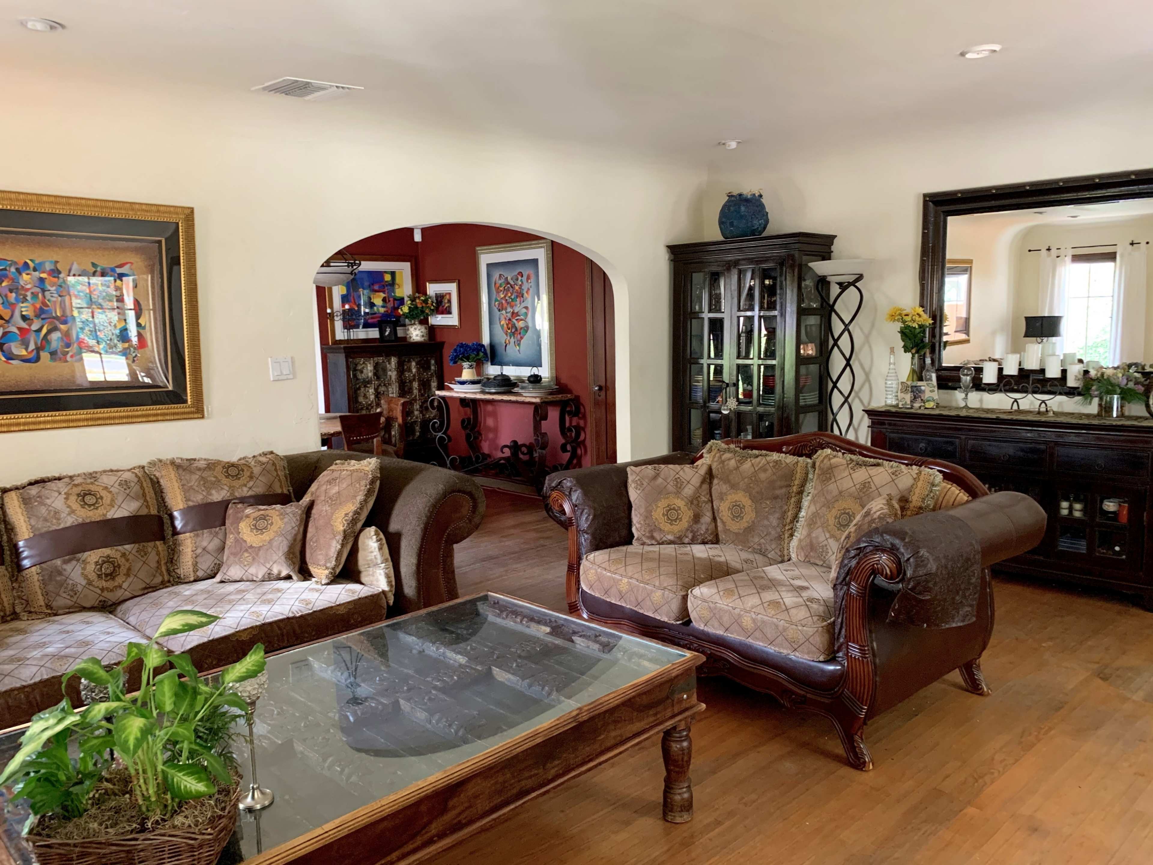 A living room with two coordinated sofas, a glass coffee table, and decorative artwork on the walls.
