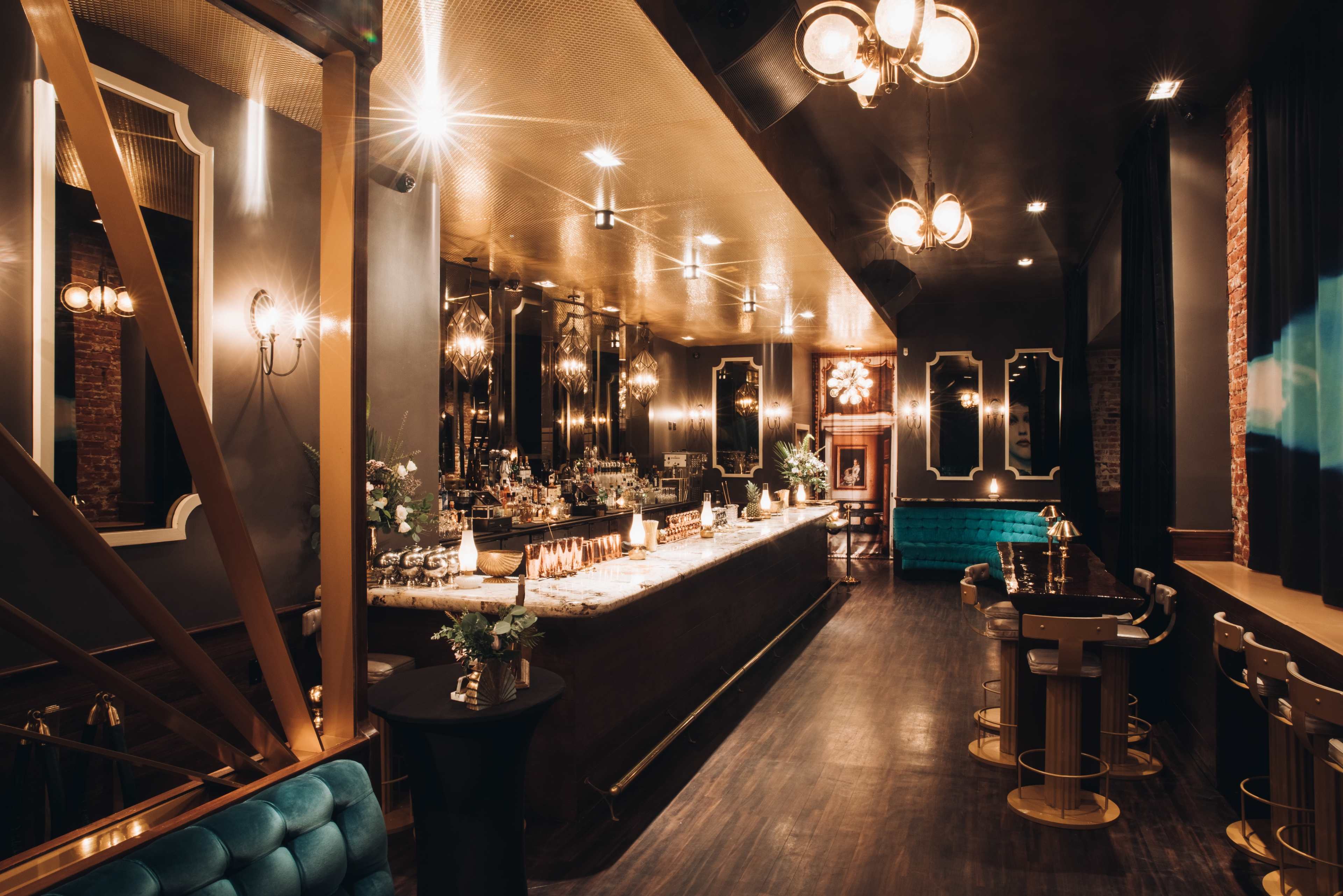 An elegant bar interior with a long, polished counter, vintage lighting fixtures, and stylish seating arrangements.