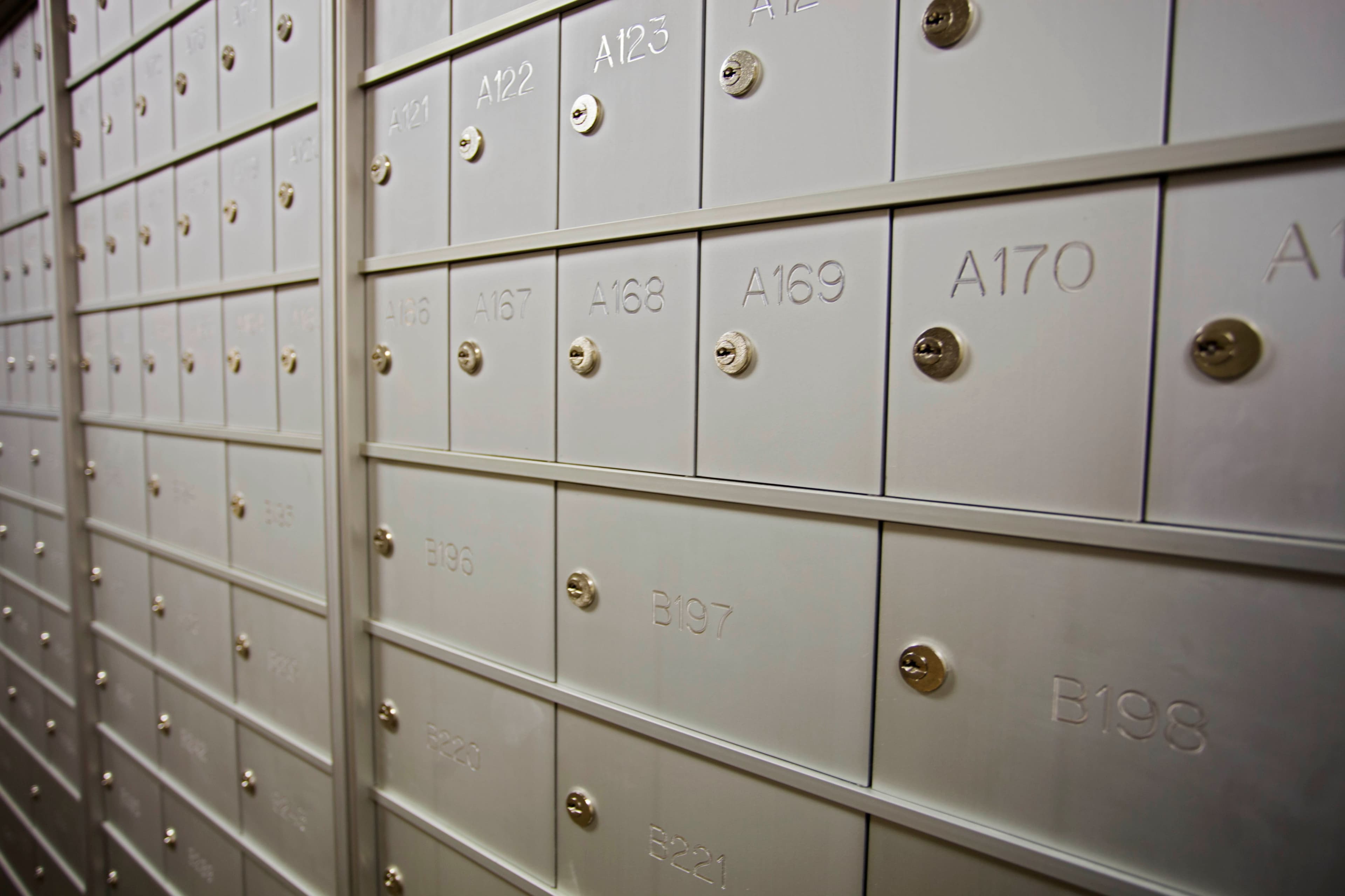 The image shows a row of metal mailboxes with numbered compartments.