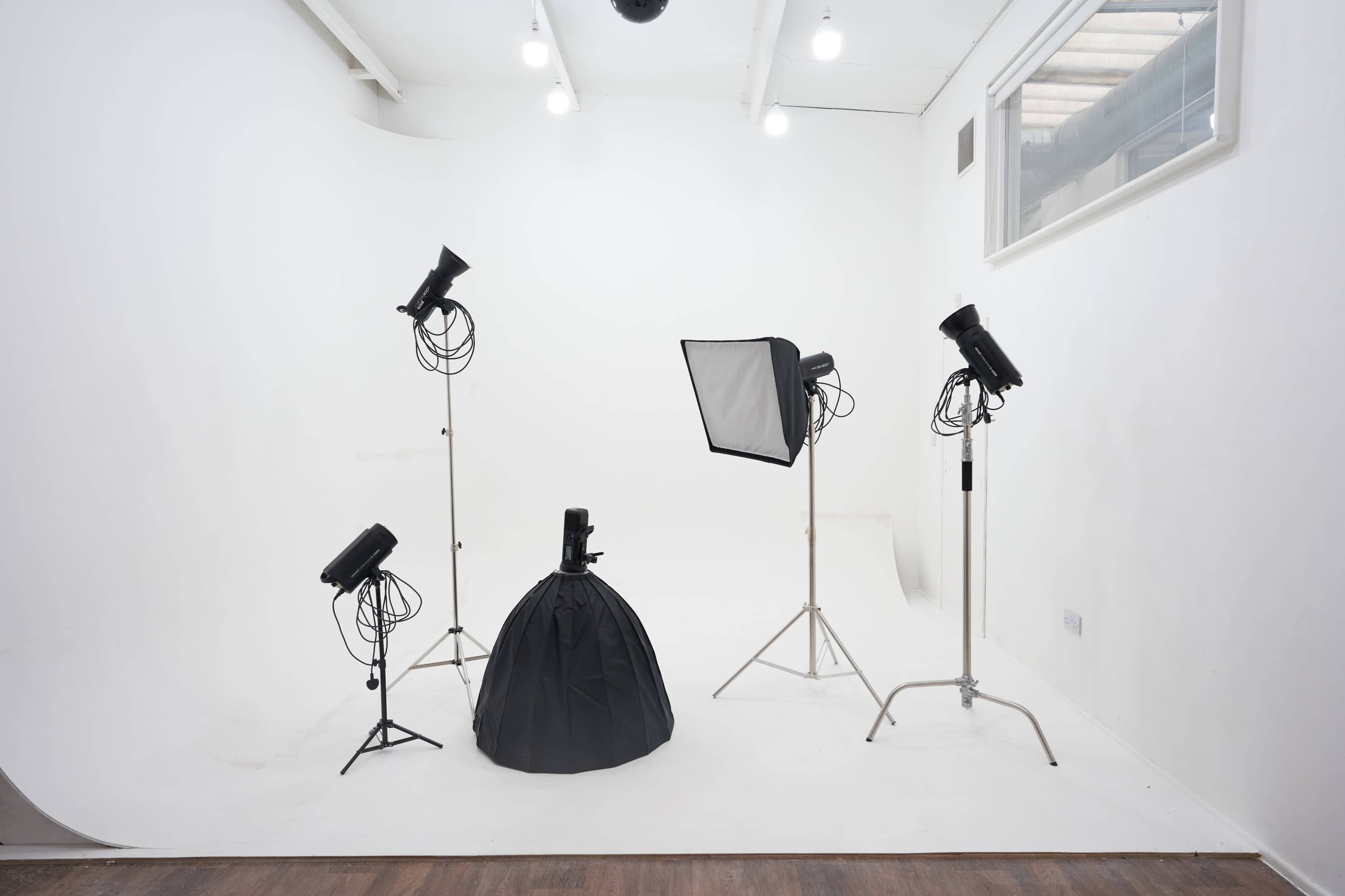 A photography studio with lighting equipment positioned around a black backdrop.