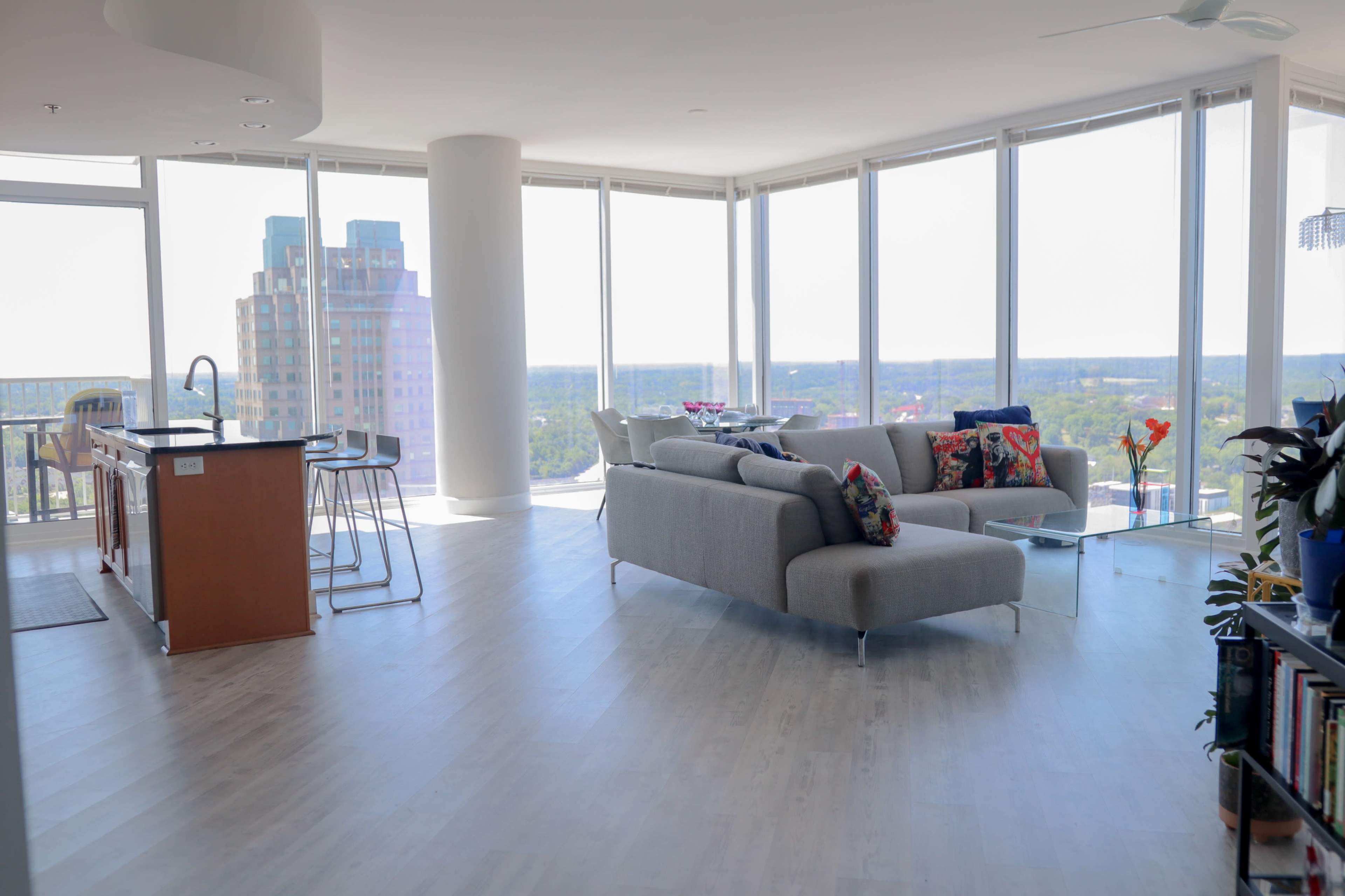 A modern, open-concept living area with large windows that provide a view of the skyline and cityscape.