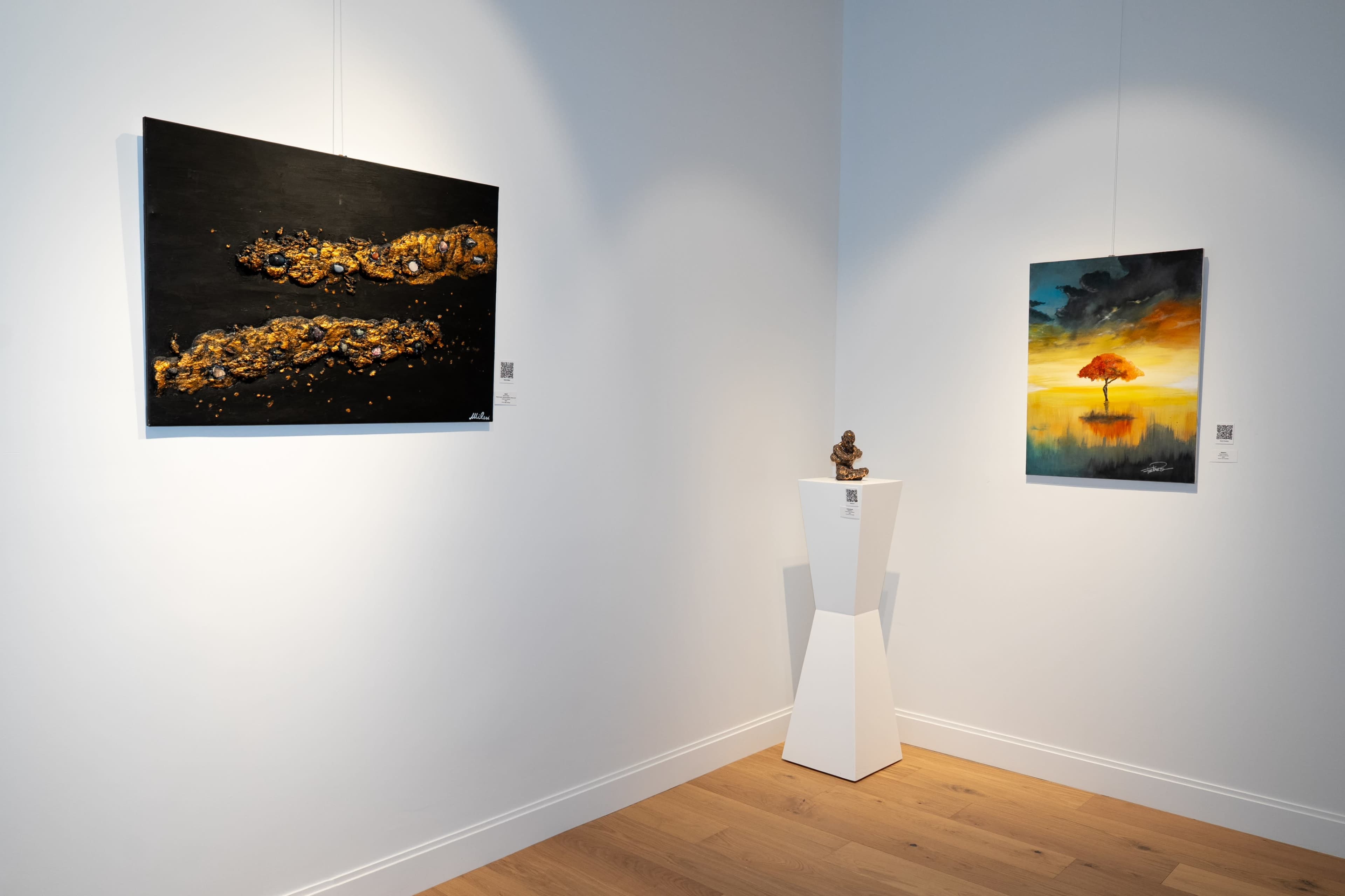 The image shows a gallery interior with two paintings on the walls and a sculpture on a pedestal in the center.