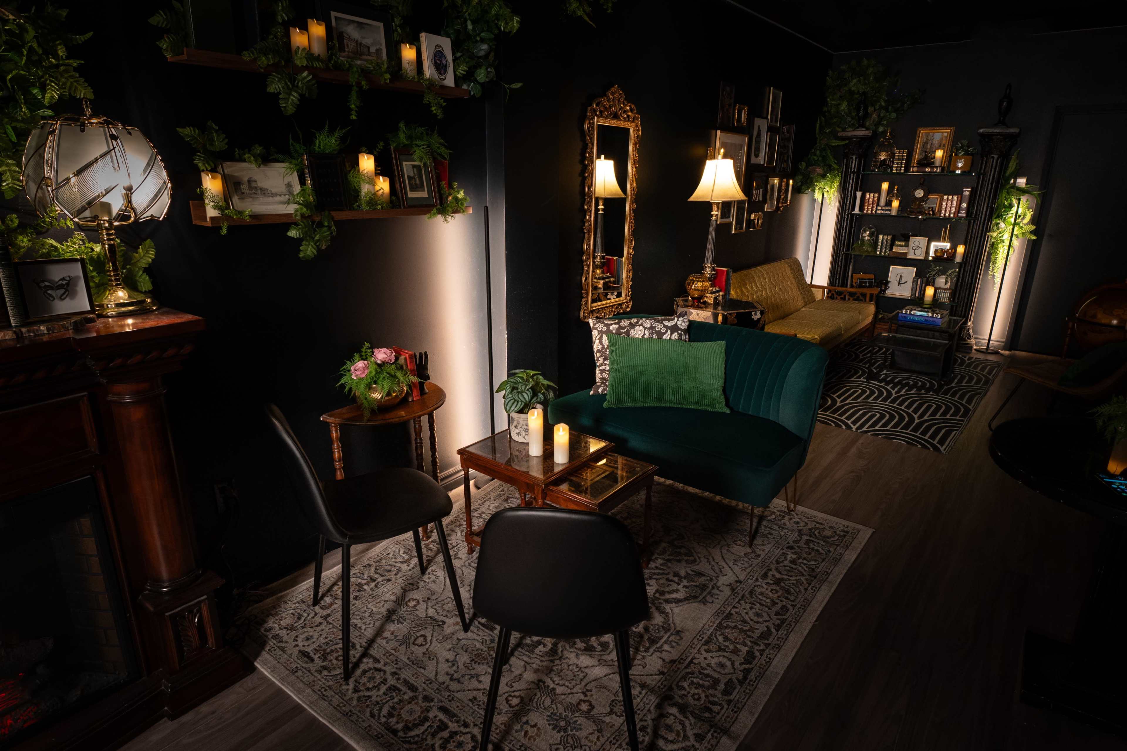 A cozy interior space featuring a mix of seating options, decorative plants, and soft lighting, along with a fireplace and bookshelves.