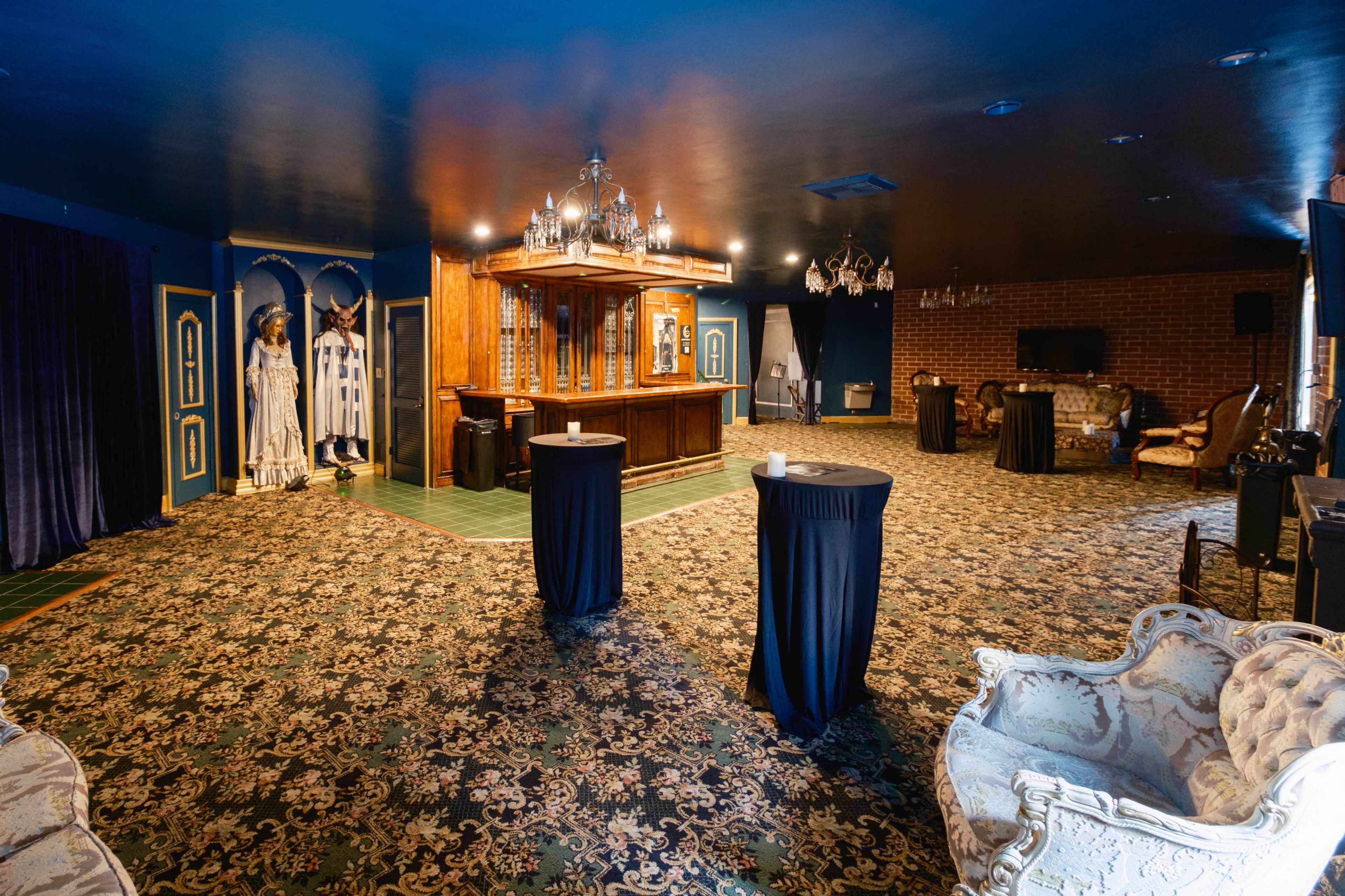 A spacious interior room with a bar, elegant seating arrangements, and decorative elements, featuring a patterned carpet and walls painted in dark colors.
