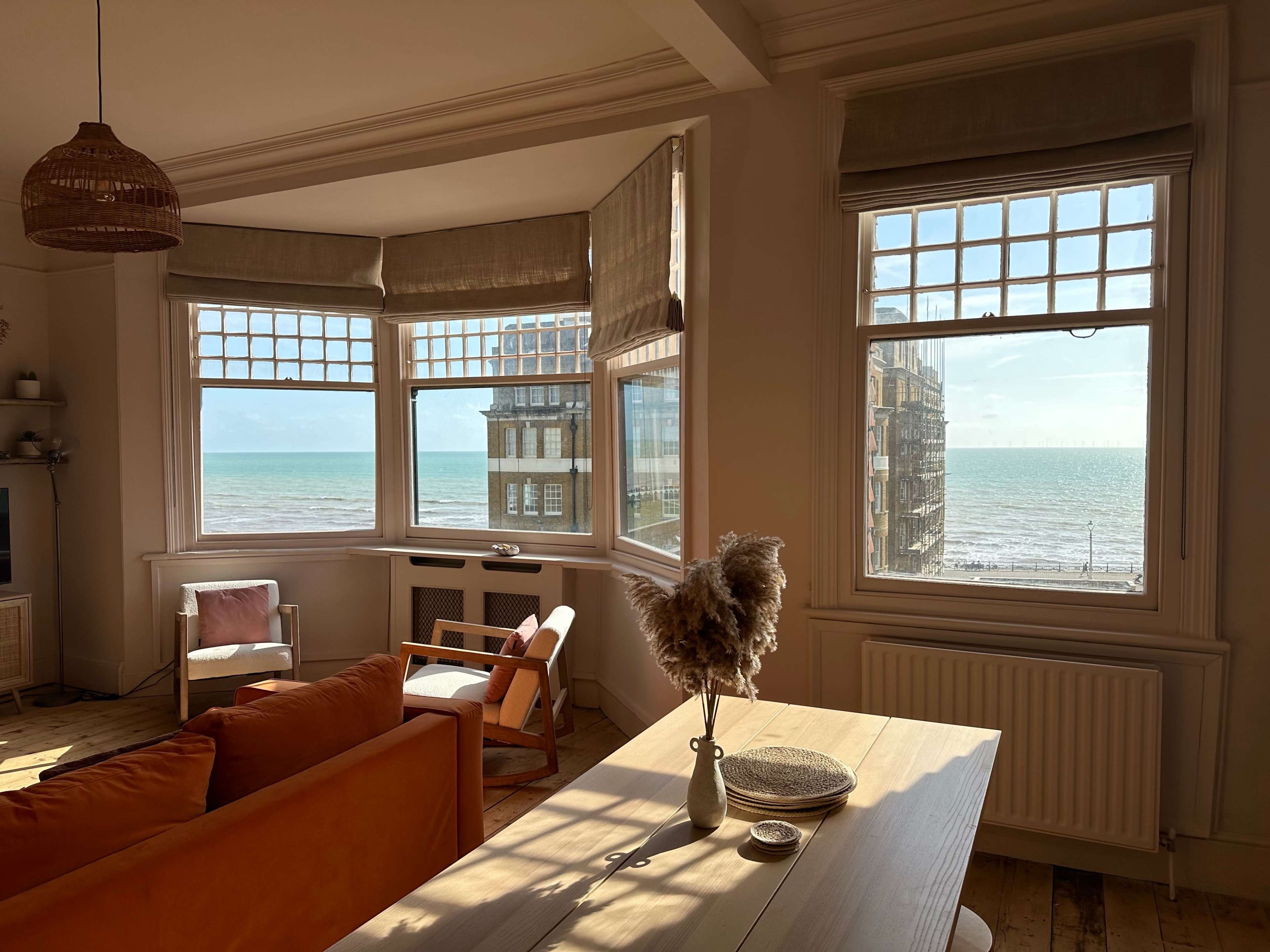 A bright living room with large windows overlooking the ocean.