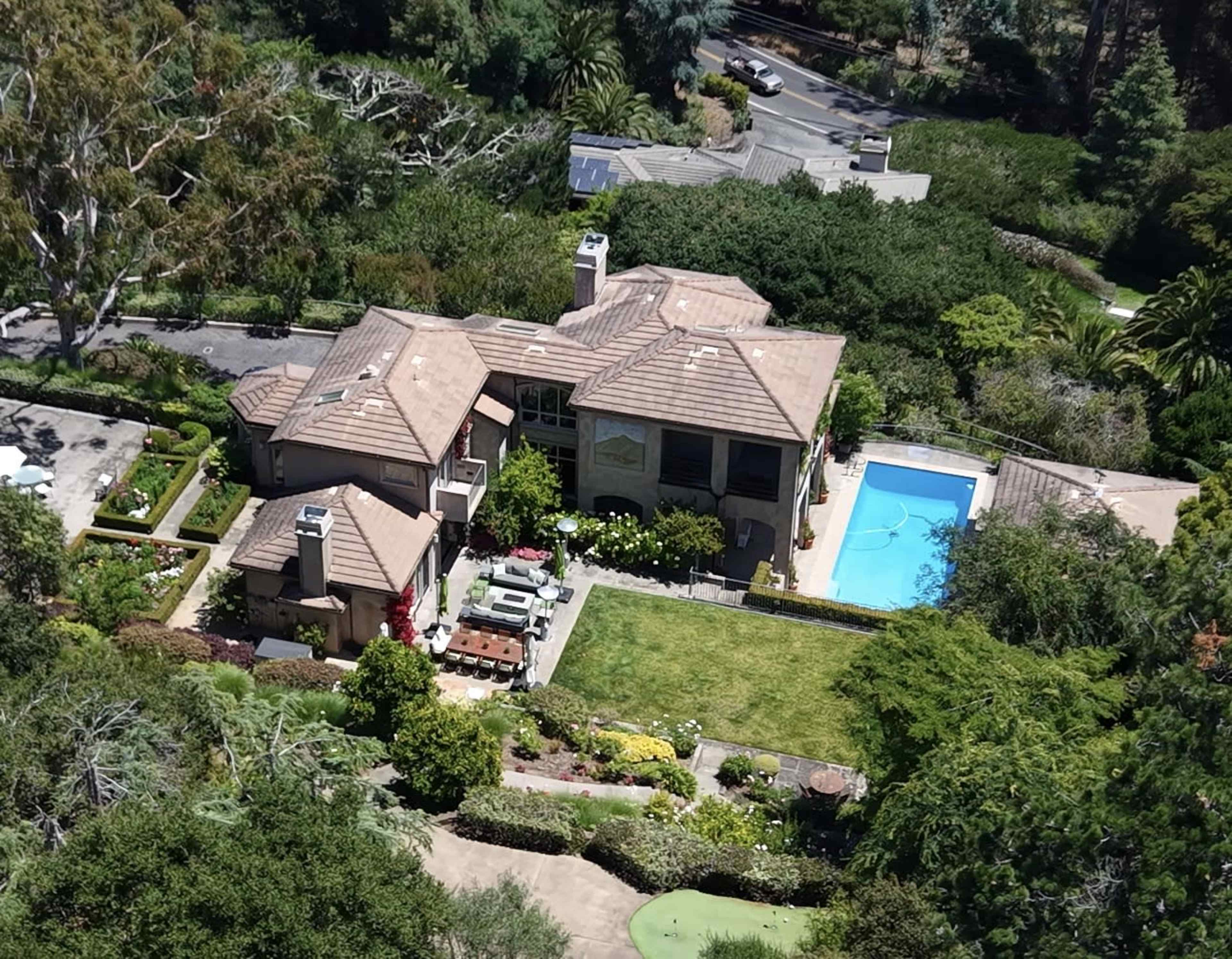 The image shows a spacious suburban house with a pool, surrounded by a well-maintained garden and trees.