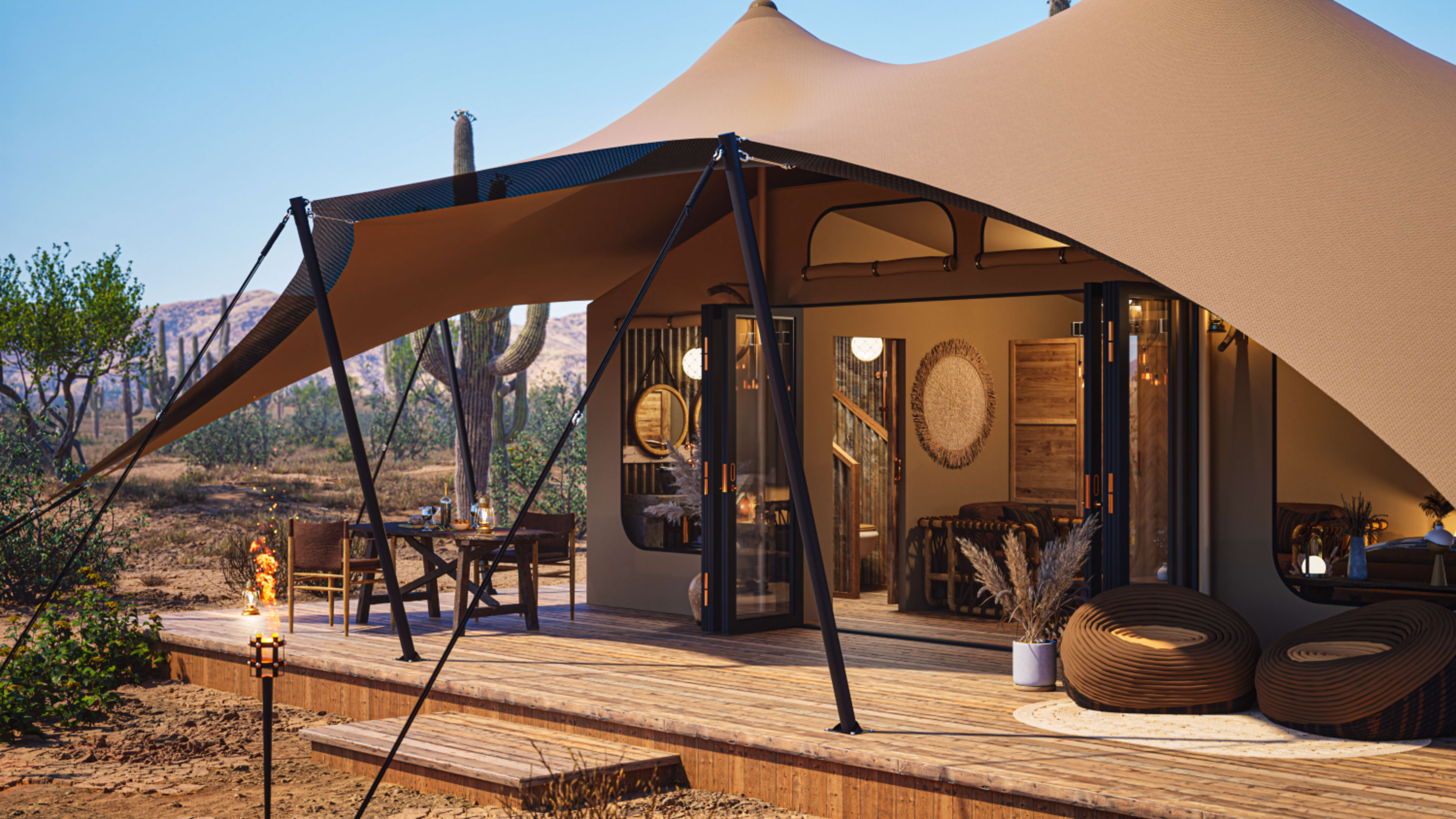 A modern tent structure with a large awning is set on a wooden deck in a desert landscape, surrounded by cacti and sparse vegetation.